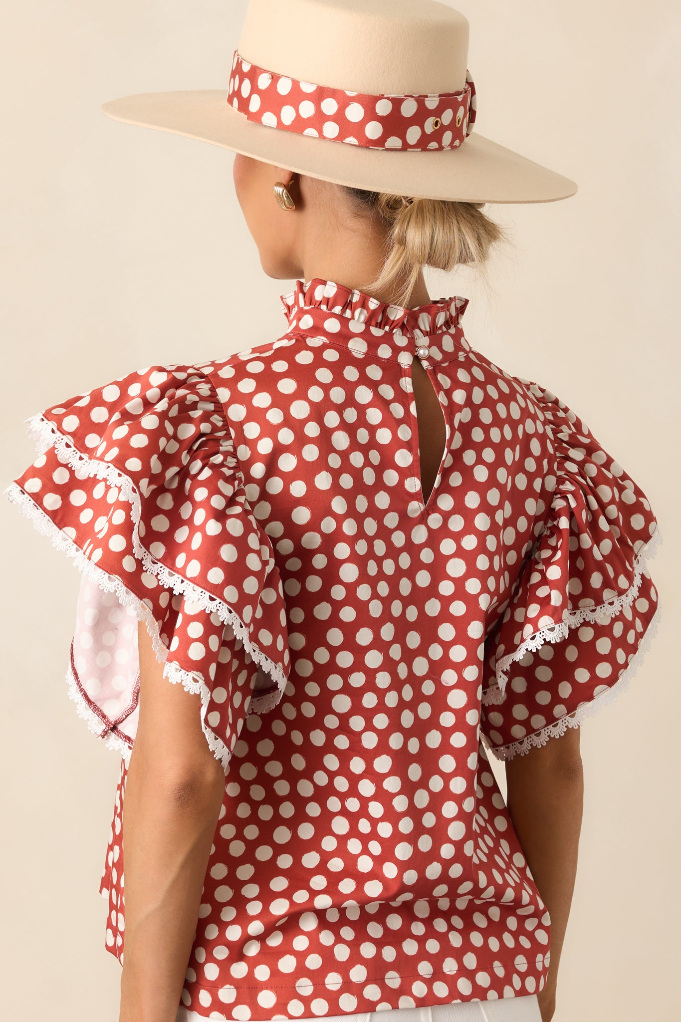 Rear view of the polka dot top with back keyhole button closure and ruffled sleeves
