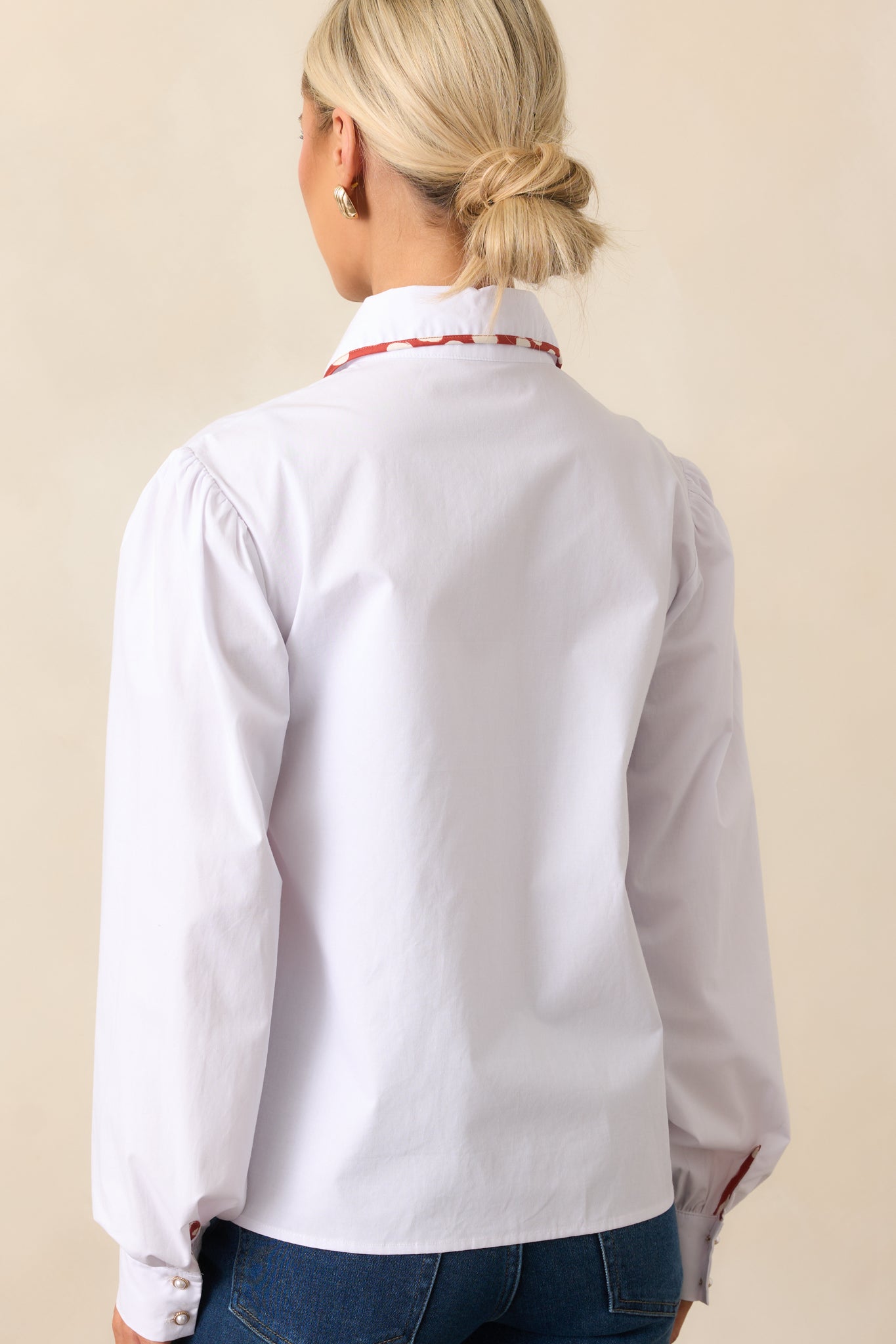 Rear view of the white top with long sleeves and relaxed silhouette.