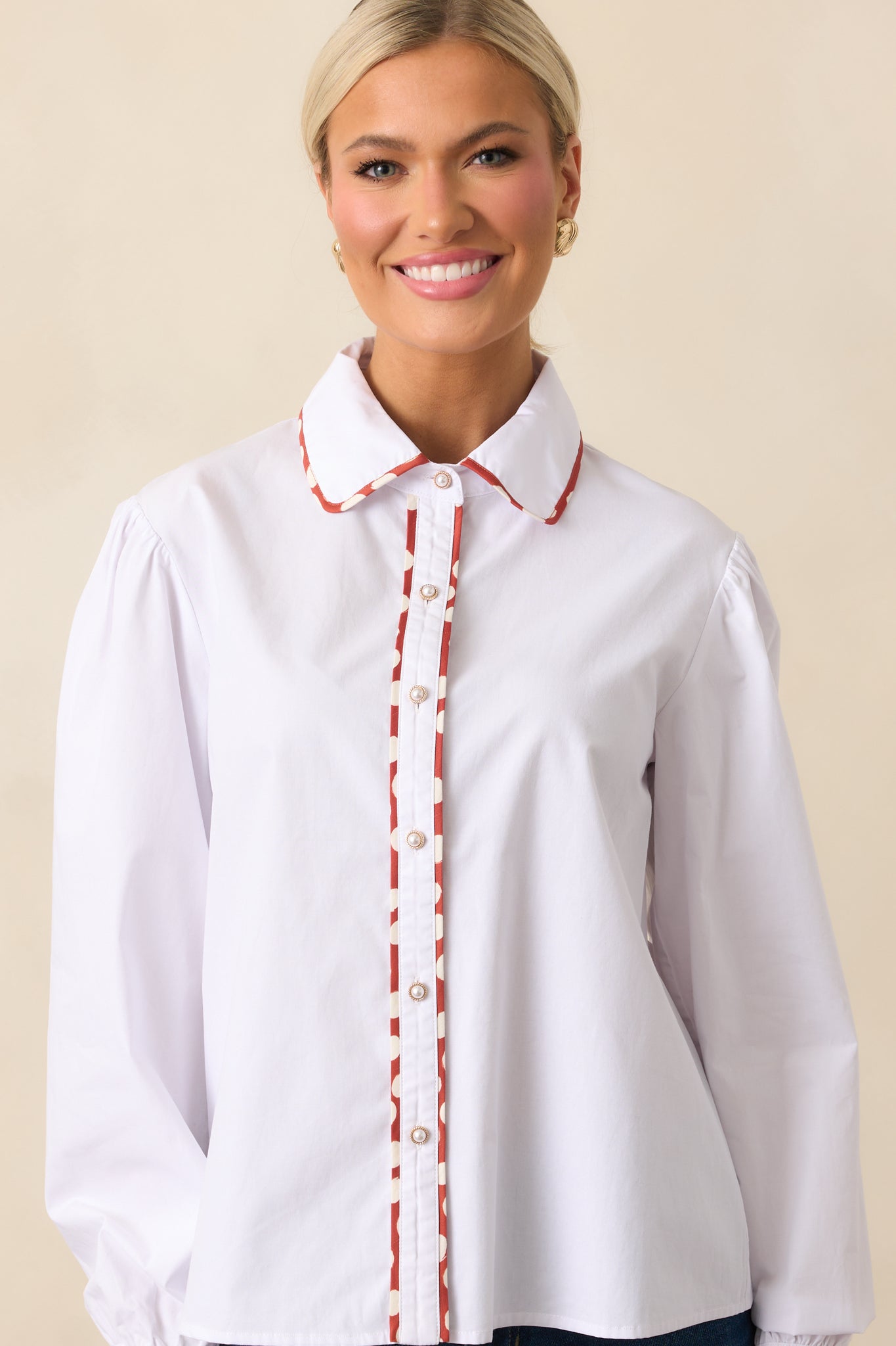 Detailed front of the top featuring polka dot trim throughout the white fabric.