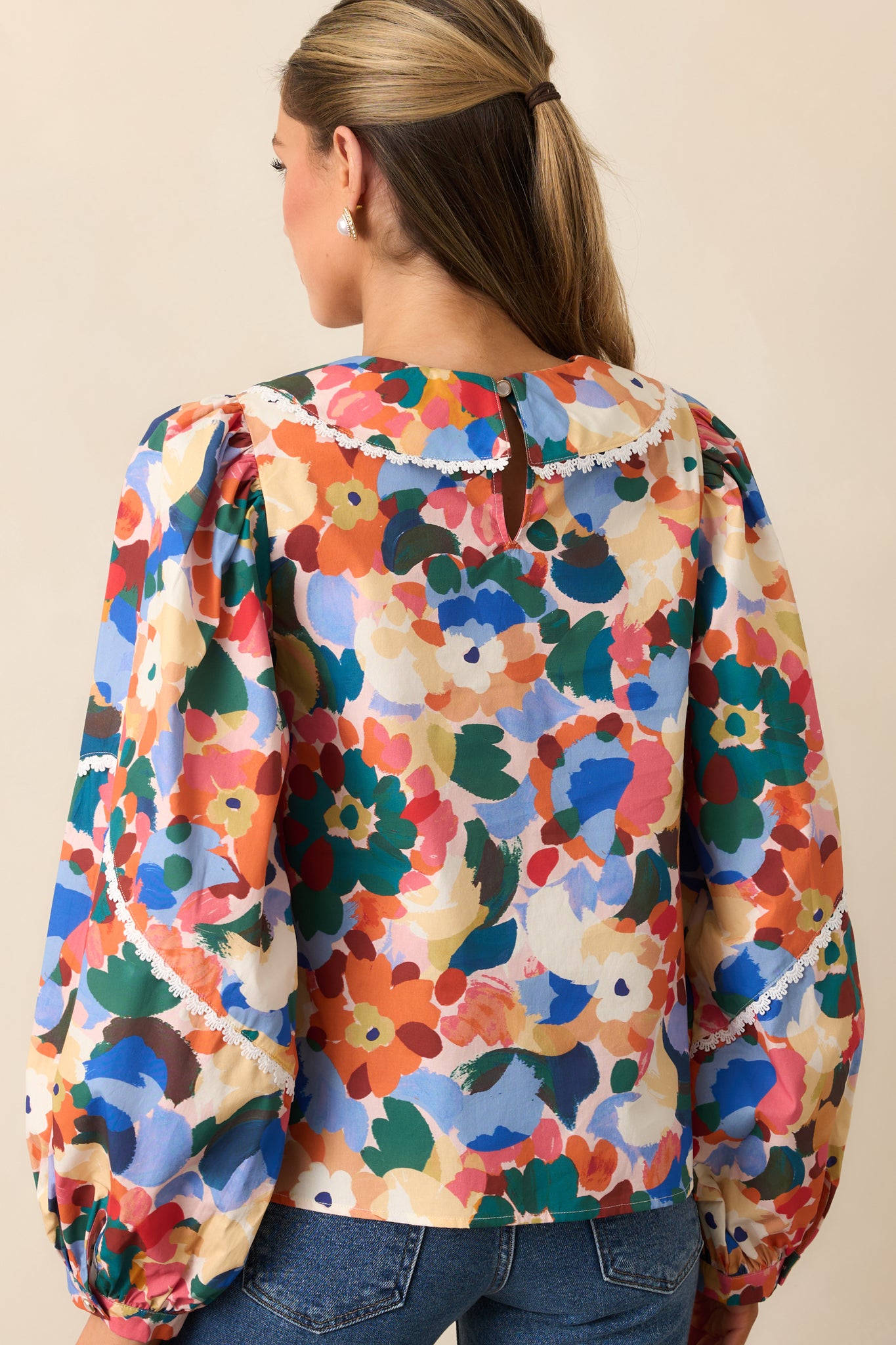Rear view of the top featuring a back keyhole closure and puff sleeves.