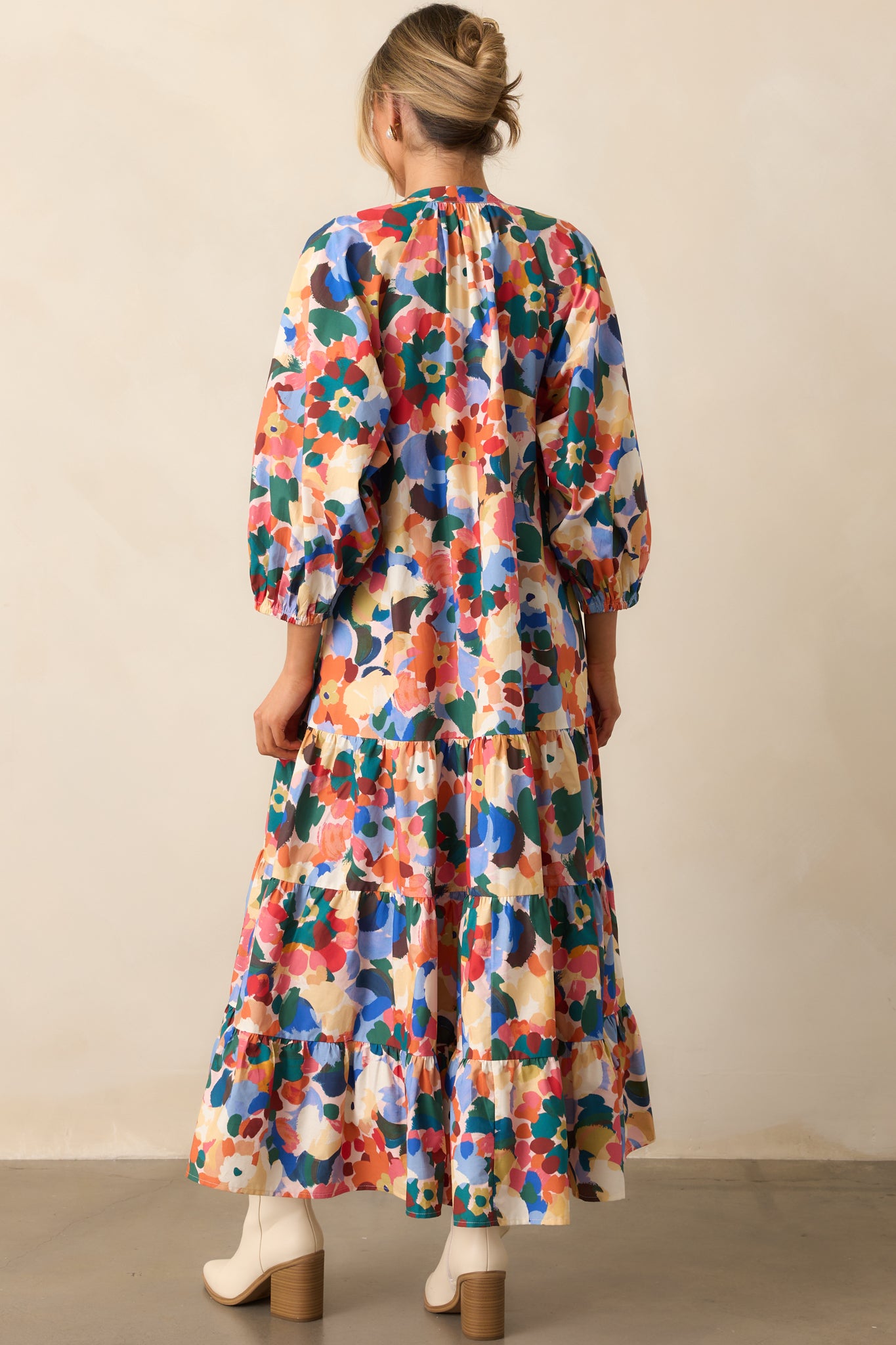 Rear view of the maxi dress highlighting long puff sleeves with elastic cuffs and tiered skirt silhouette.