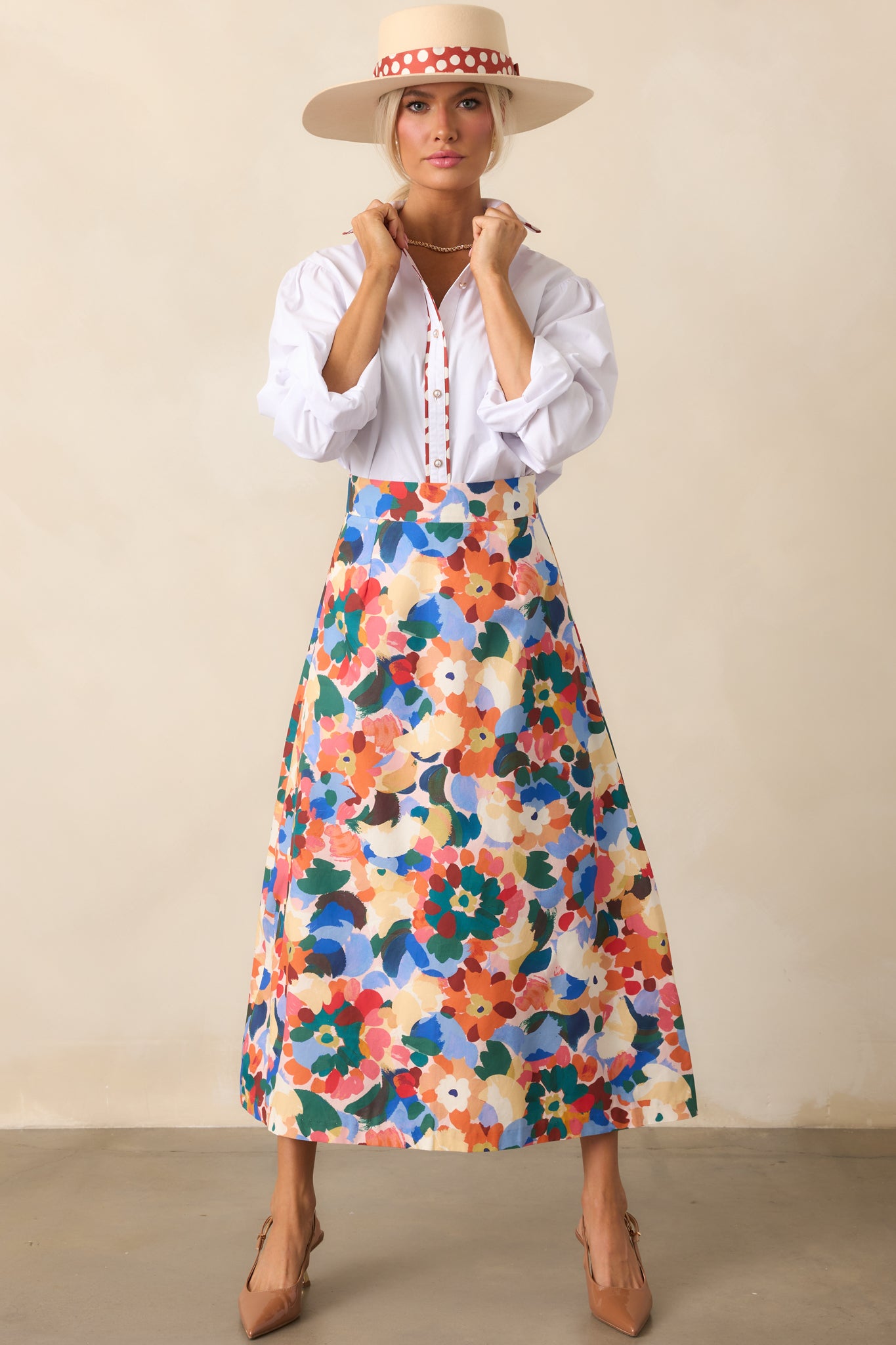 Orange multicolor floral midi skirt with a high-rise waist and flowing silhouette.