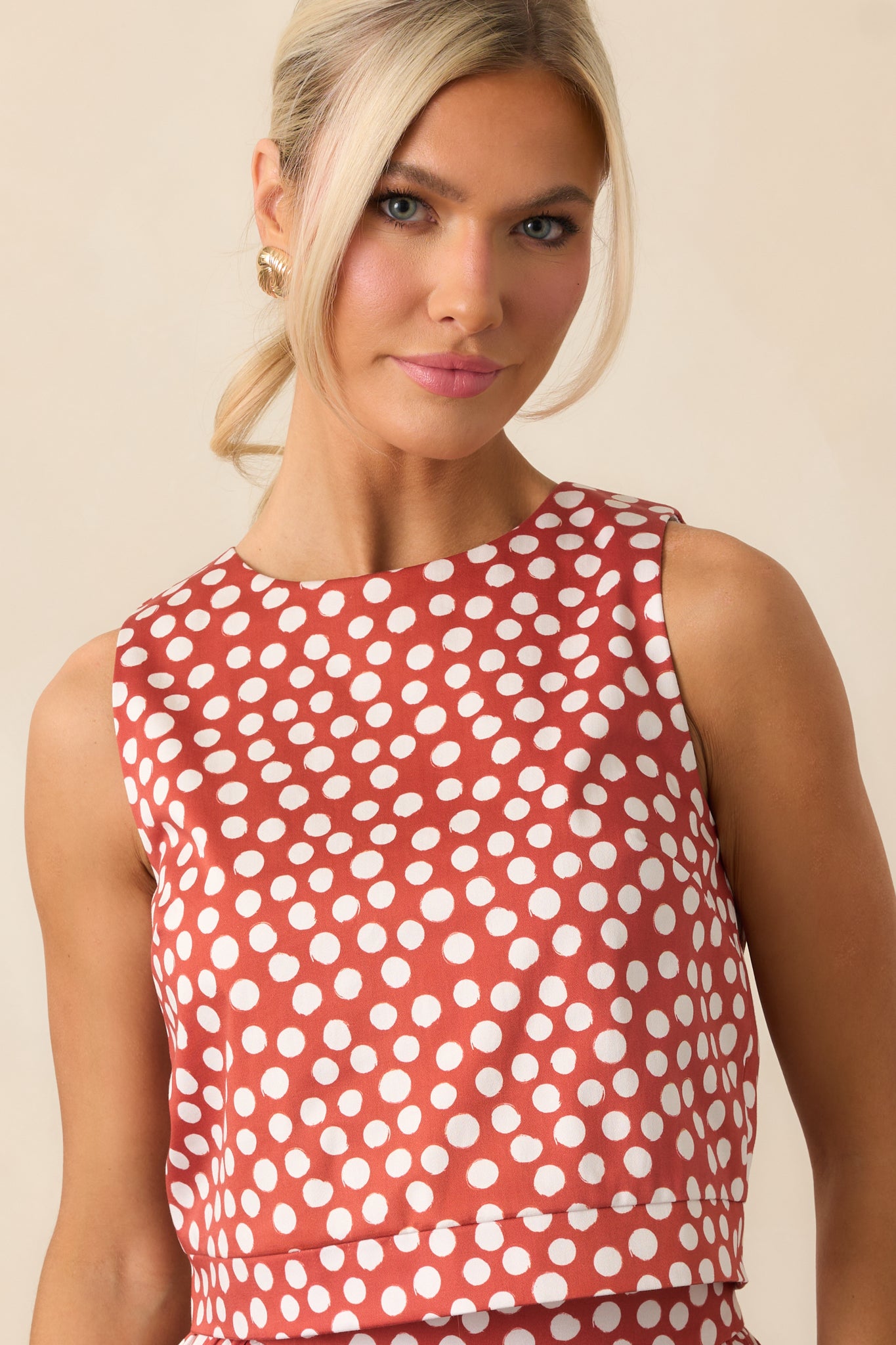 Structured sleeveless top with ivory polka dots and darted front seams.