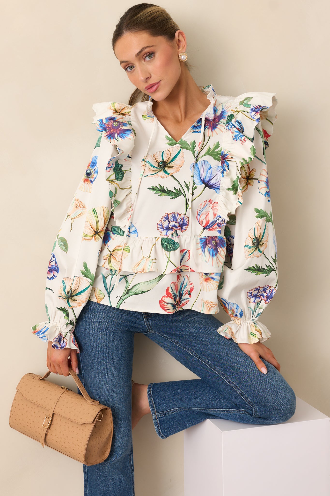 Relaxed-fit ivory top with soft floral pattern and flowing silhouette.