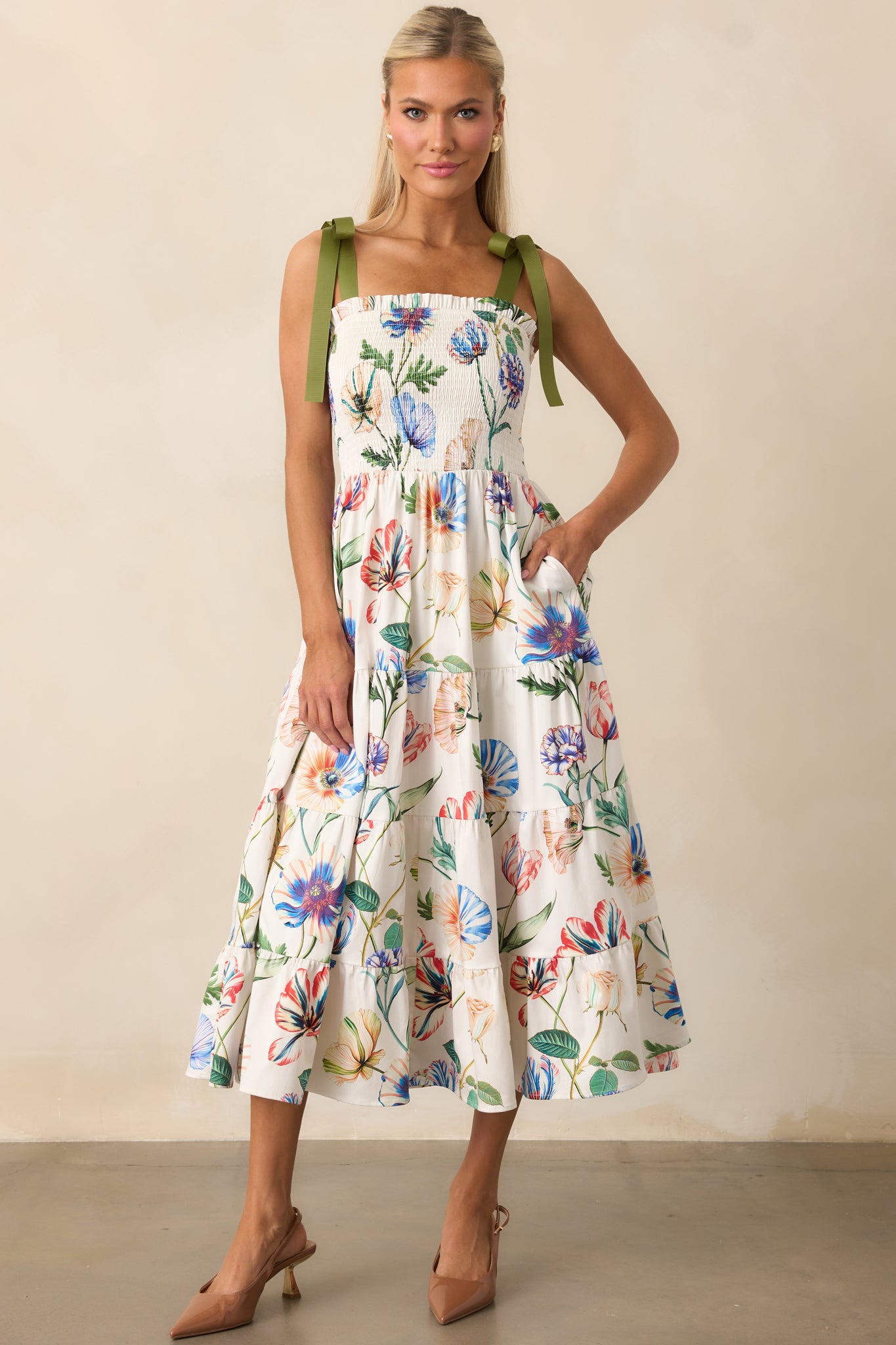 Floral midi dress with ruffle-trimmed square neckline and adjustable green bow straps.