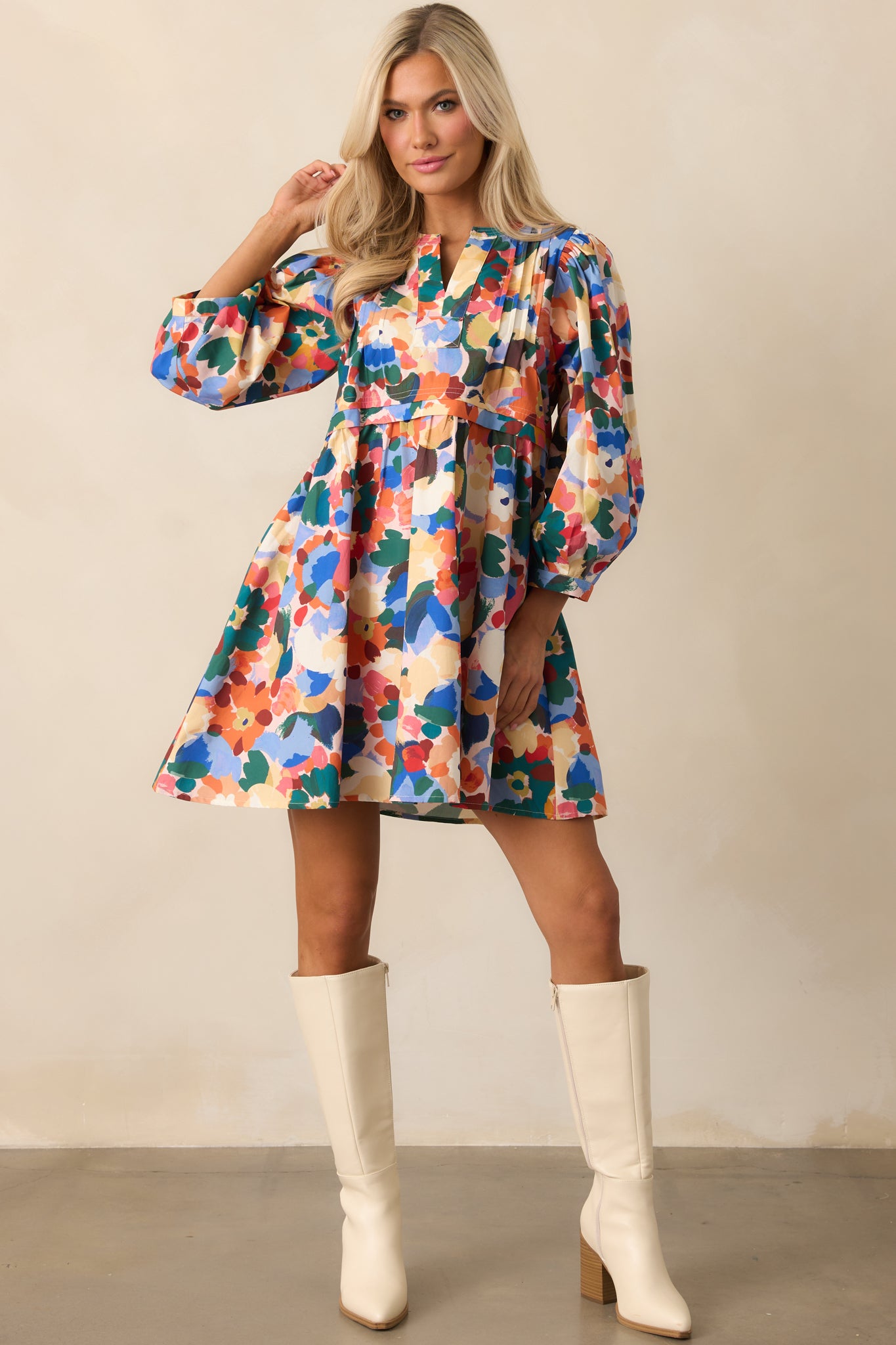 Orange floral mini dress with subtle front pleats and structured balloon sleeves.