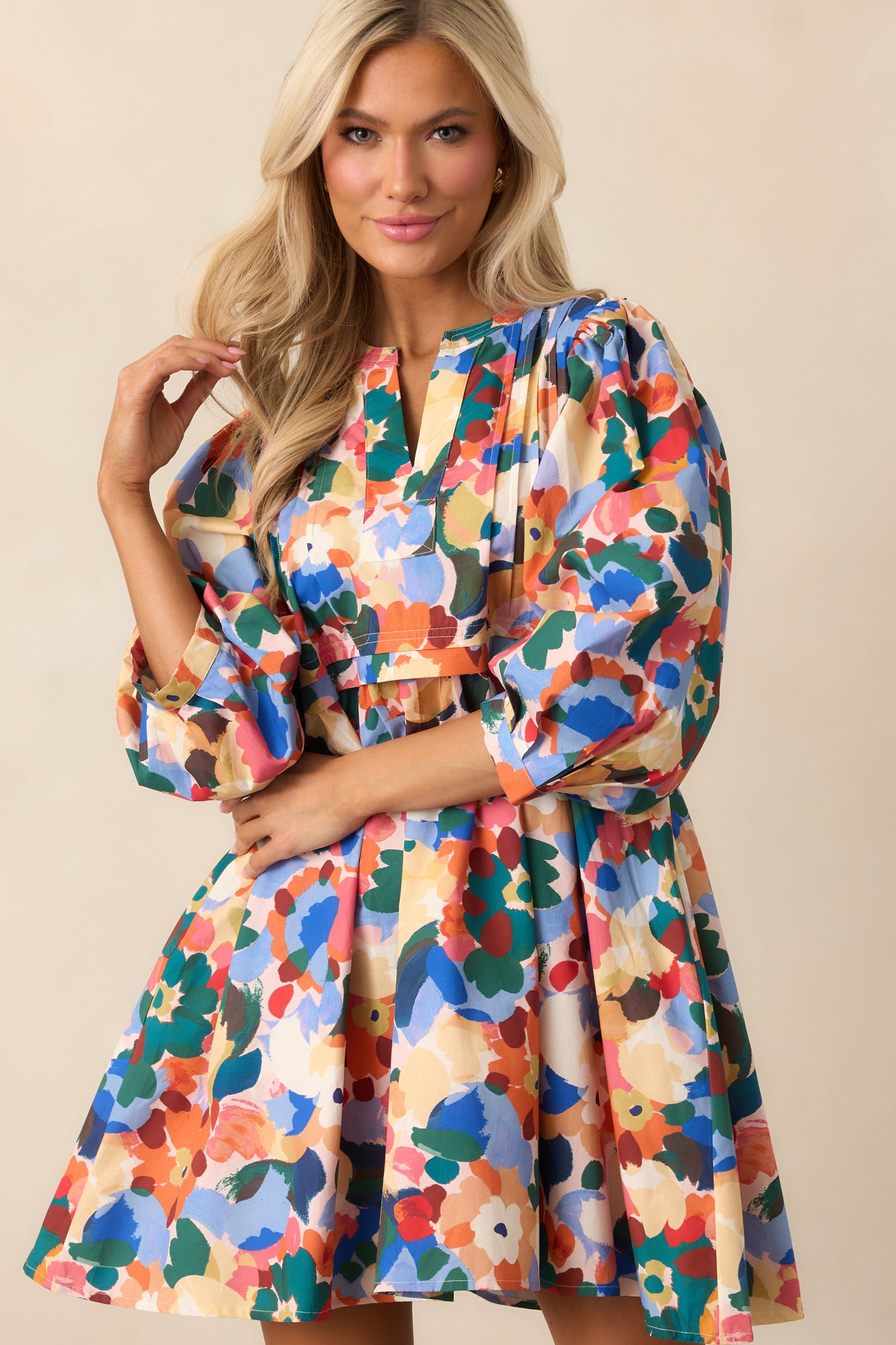 Mini dress with multicolor floral pattern and soft, structured sleeve design.