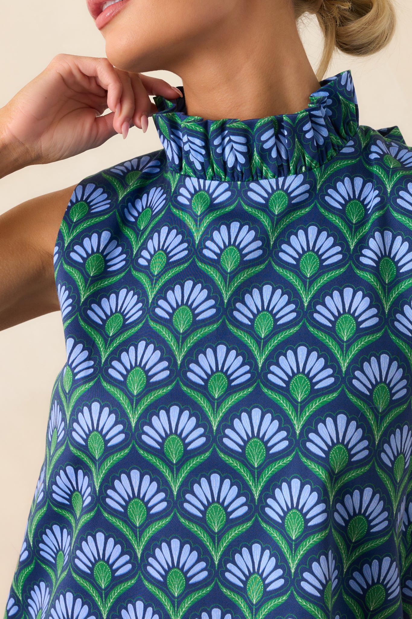 Close-up of the high ruffled mock neckline with self-tie bow and colorful geometric print fabric.