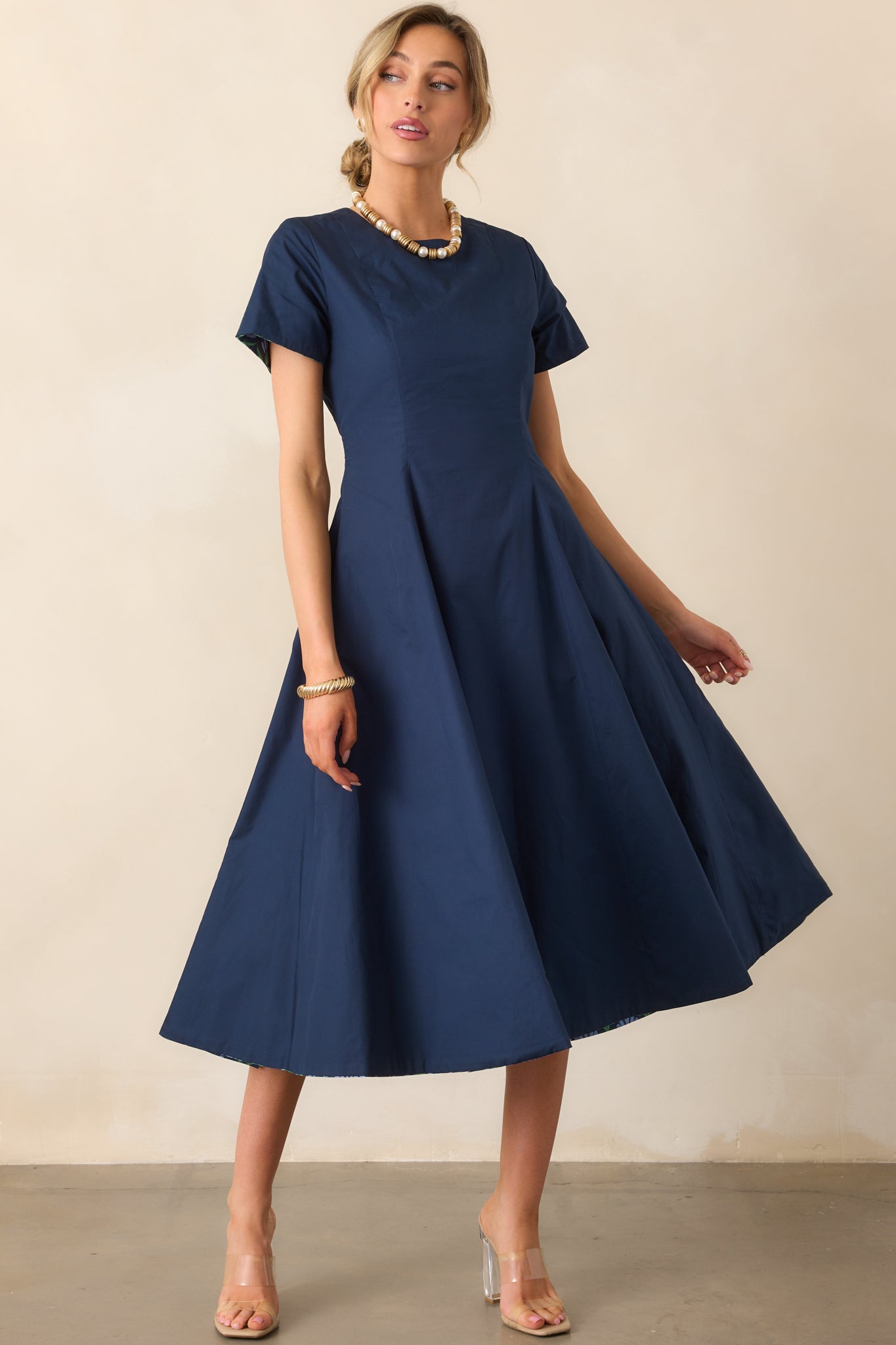 Dress highlighting short sleeves and the smooth solid midnight blue fabric.