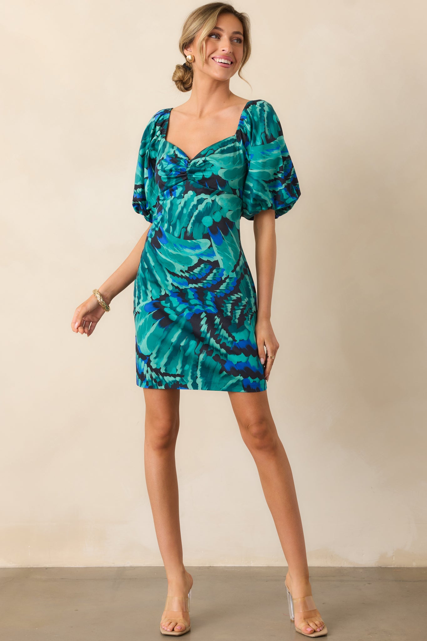 Vibrant printed mini dress with short puff sleeves and a fitted waist creating a flattering shape.
