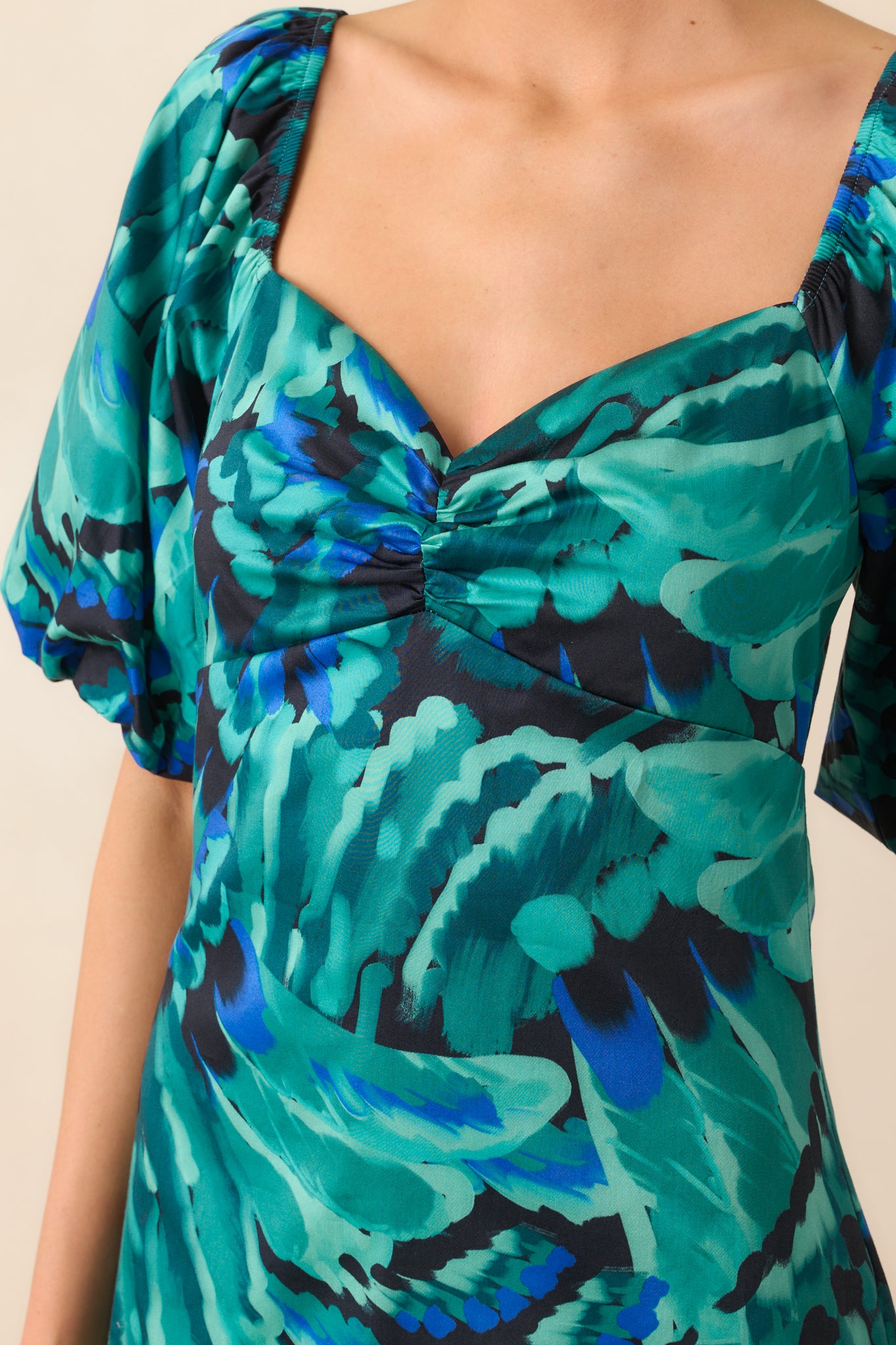 Detailed look at the vibrant blue multicolor fabric and fine stitching around the ruched neckline.