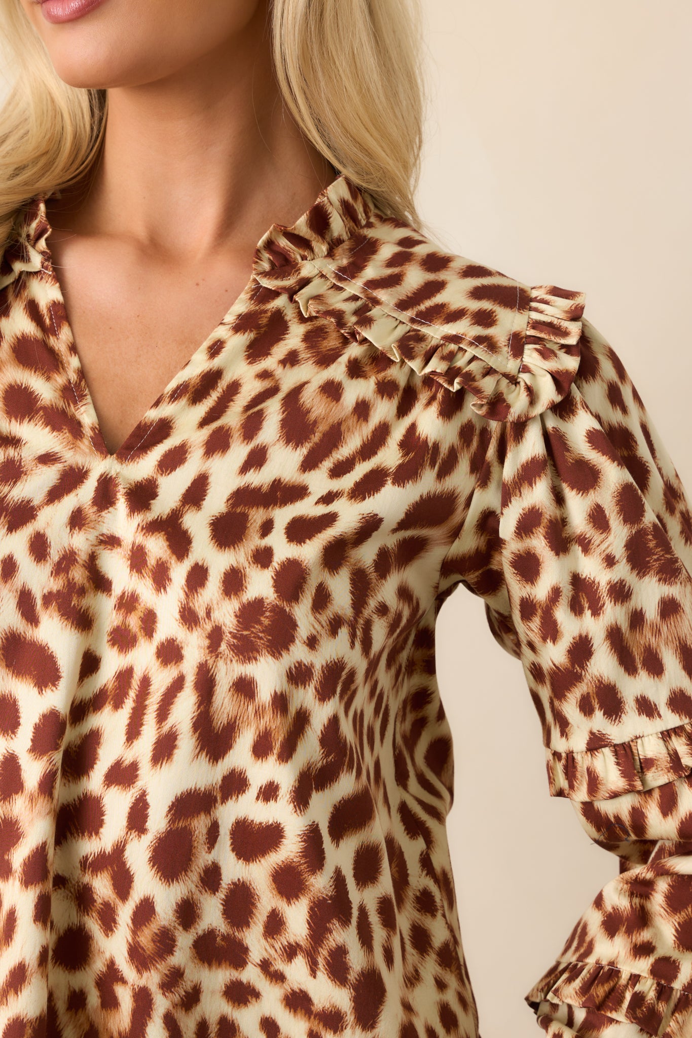 Close-up of the split v-neckline, ruffle trim, and textured fabric pattern.