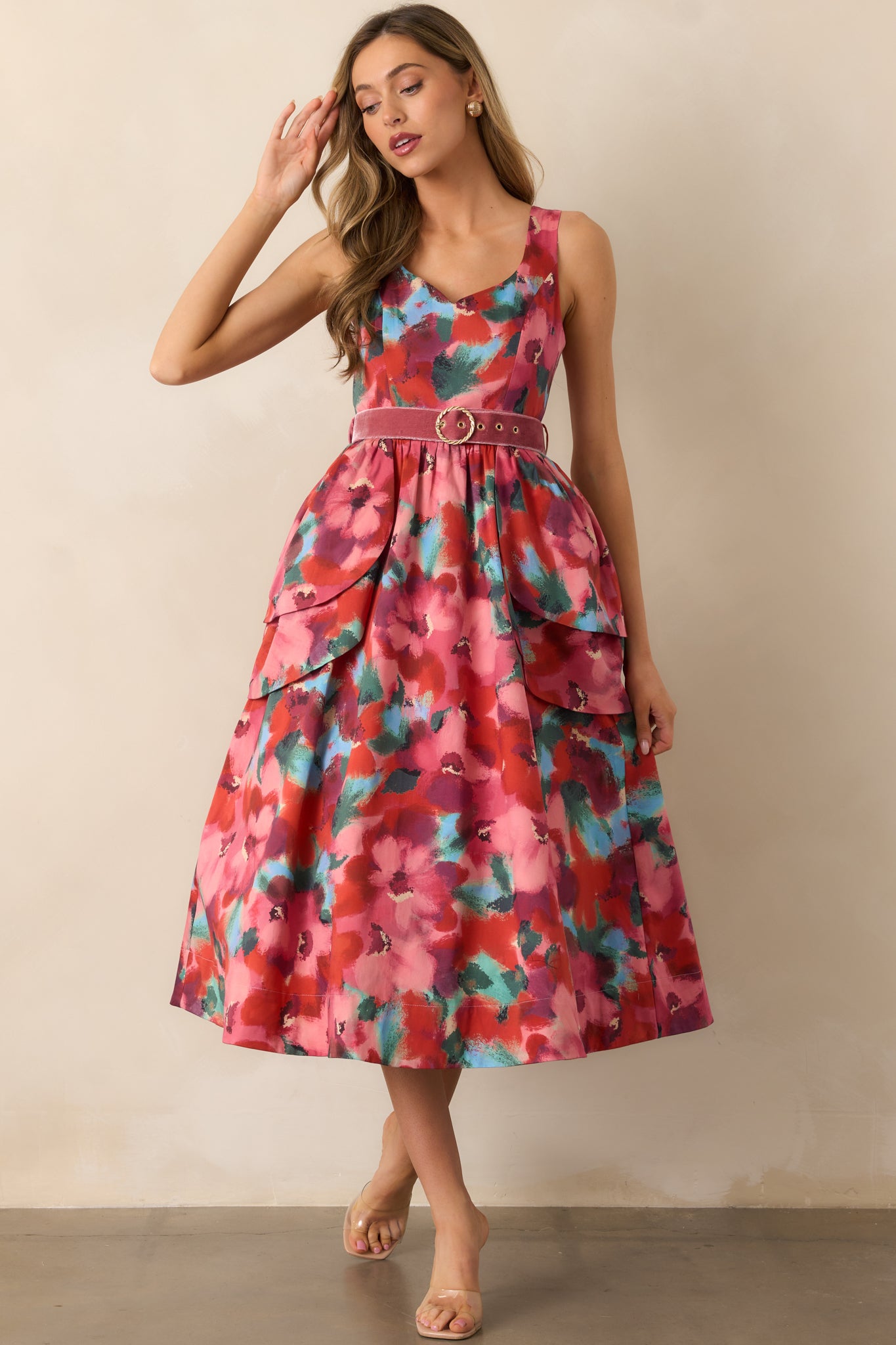 Midi dress featuring tiered peplum overskirts at the waist and a flowing floral print.