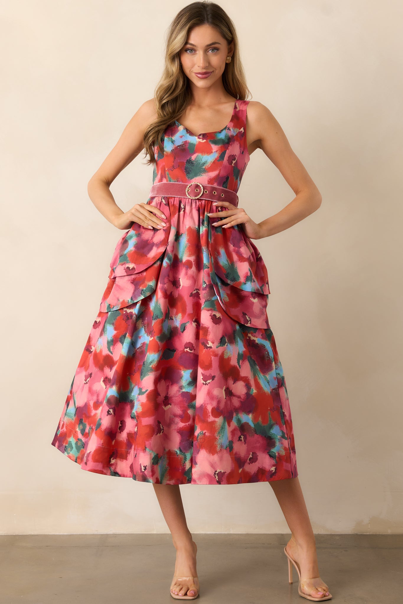 Pink floral midi dress highlighting the sleeveless cut and petal-inspired layered waist detail.
