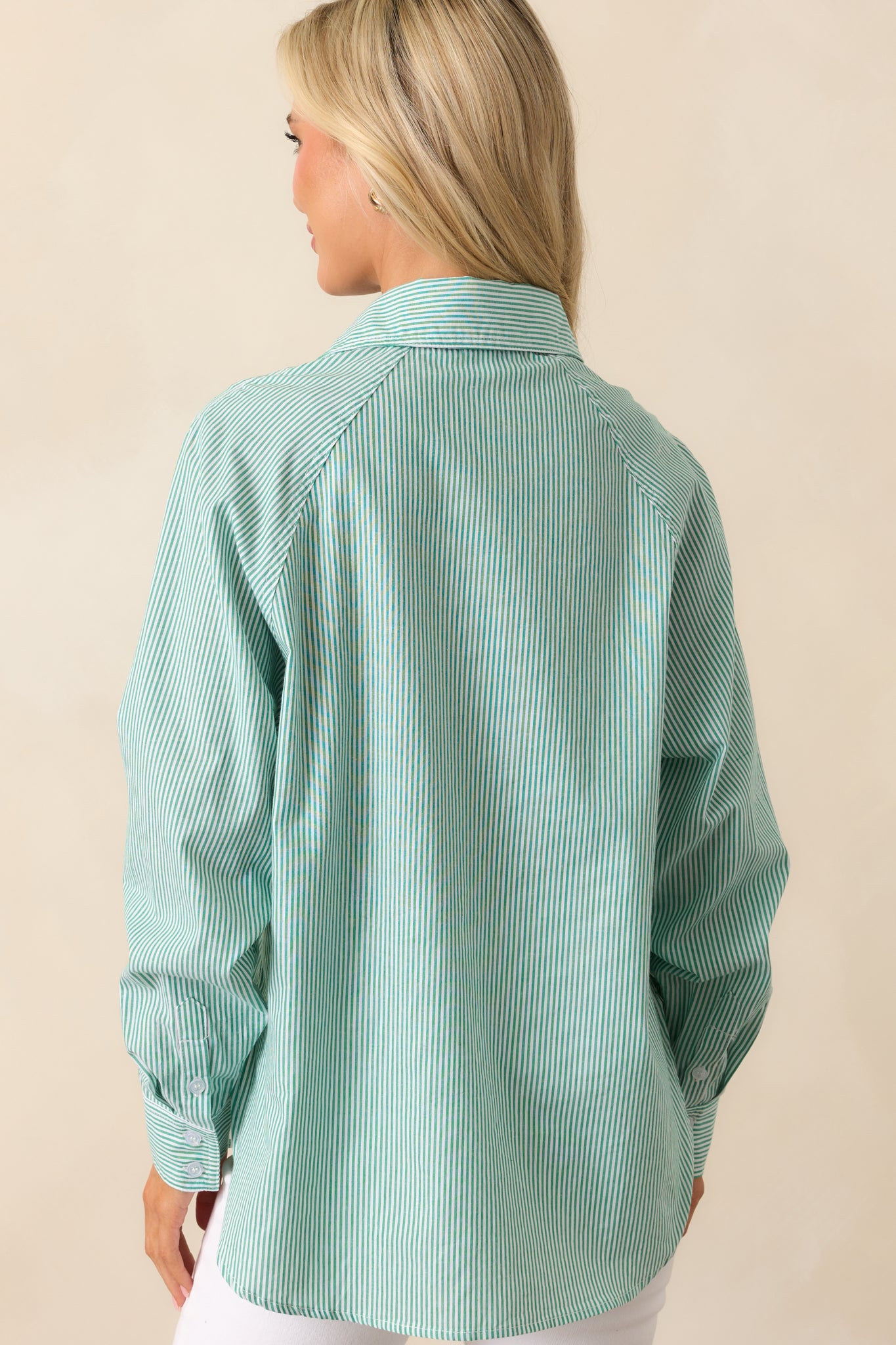 A rear view of the grass green top, emphasizing the smooth cotton fabric and classic structure.
