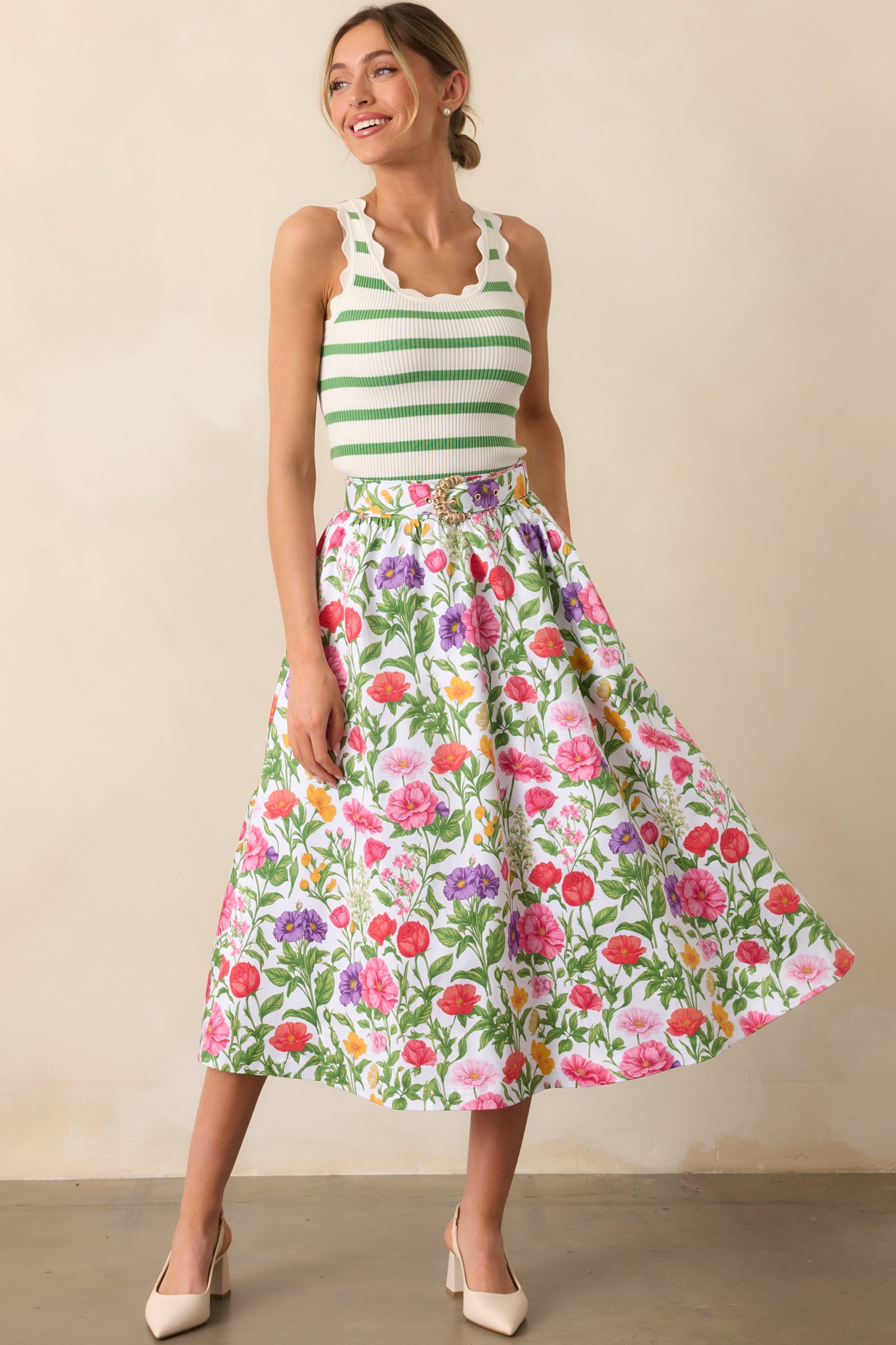This midi skirt showcases a delicate floral print throughout, with an optional belt and functional pockets for added style and practicality.