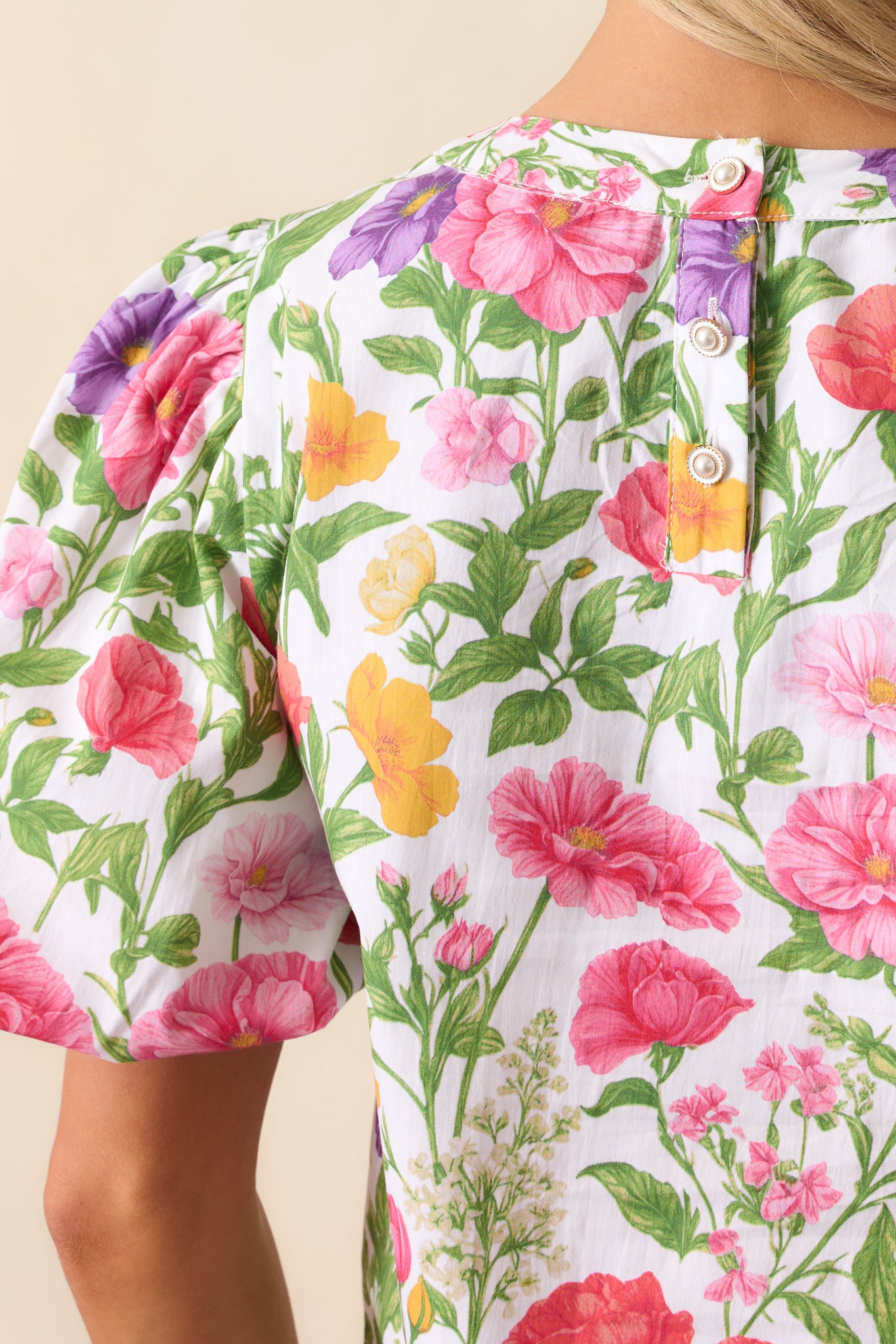 A closer view of the textured fabric, elastic sleeve cuffs, and floral print details of this colorful top.