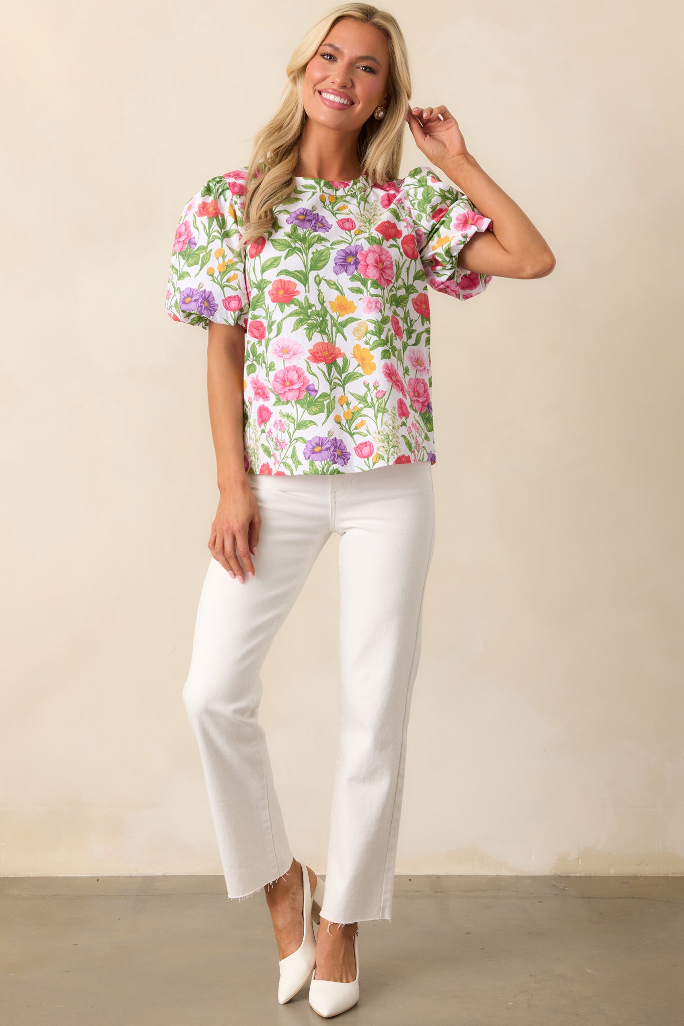 This floral top showcases a lively print, airy puff sleeves, and a classic round neckline for a charming touch