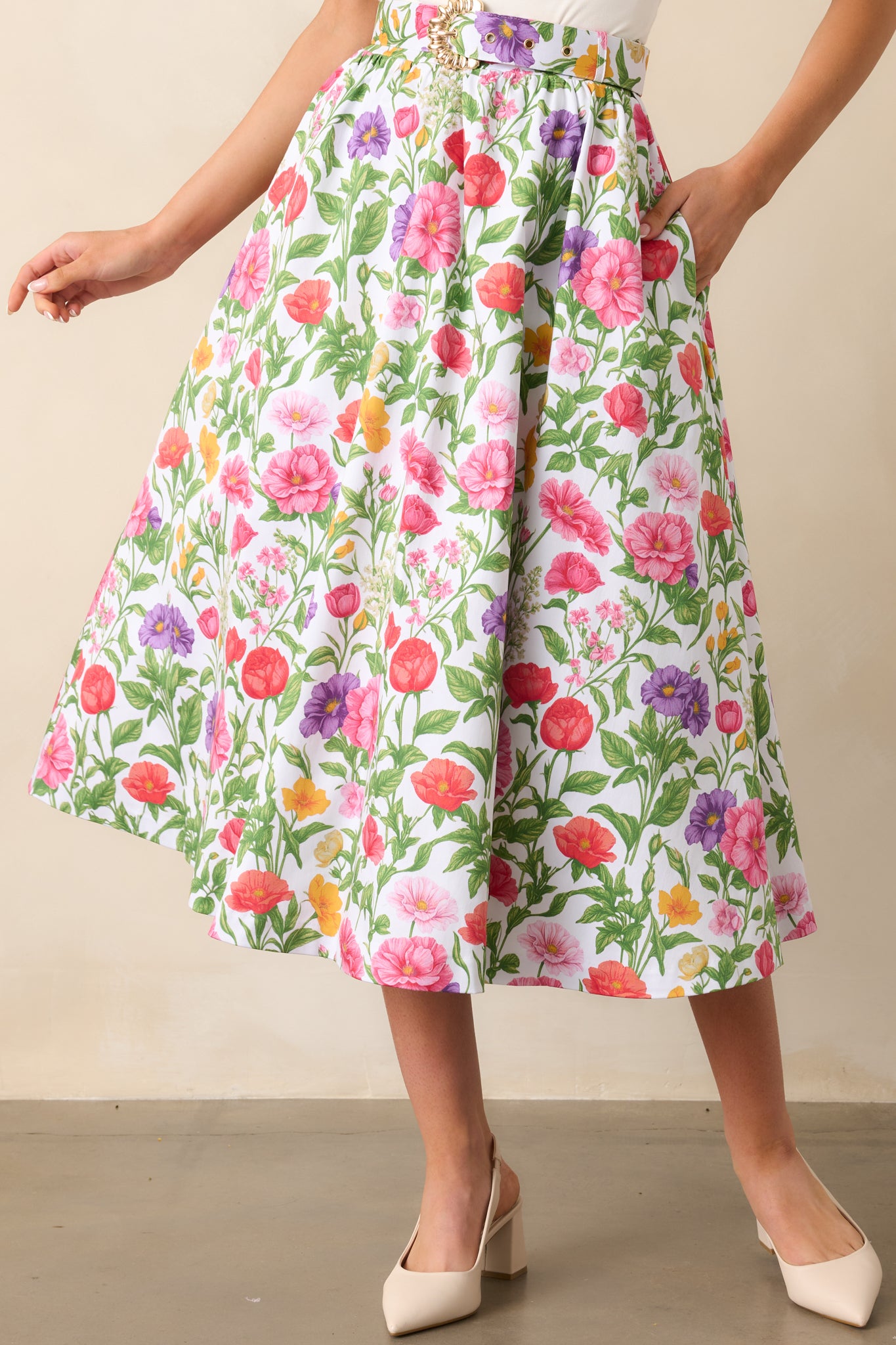 A closer view of the floral print and functional pockets of the midi skirt, highlighting the versatile design and attention to detail.