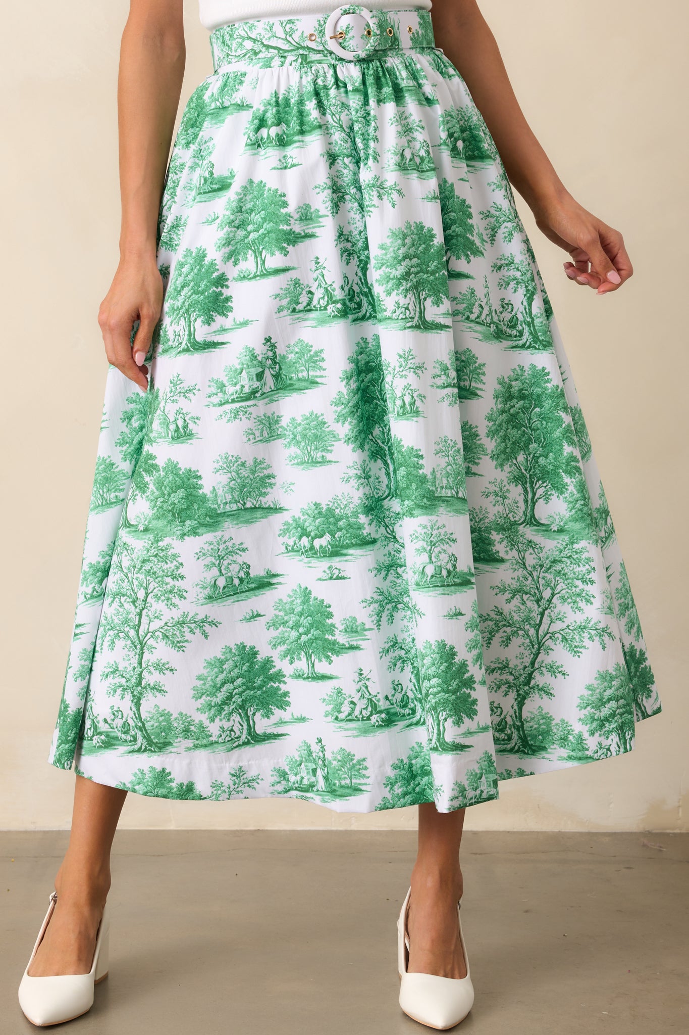 The delicate toile print and functional pockets come together in this eden green midi skirt, offering both style and functionality.