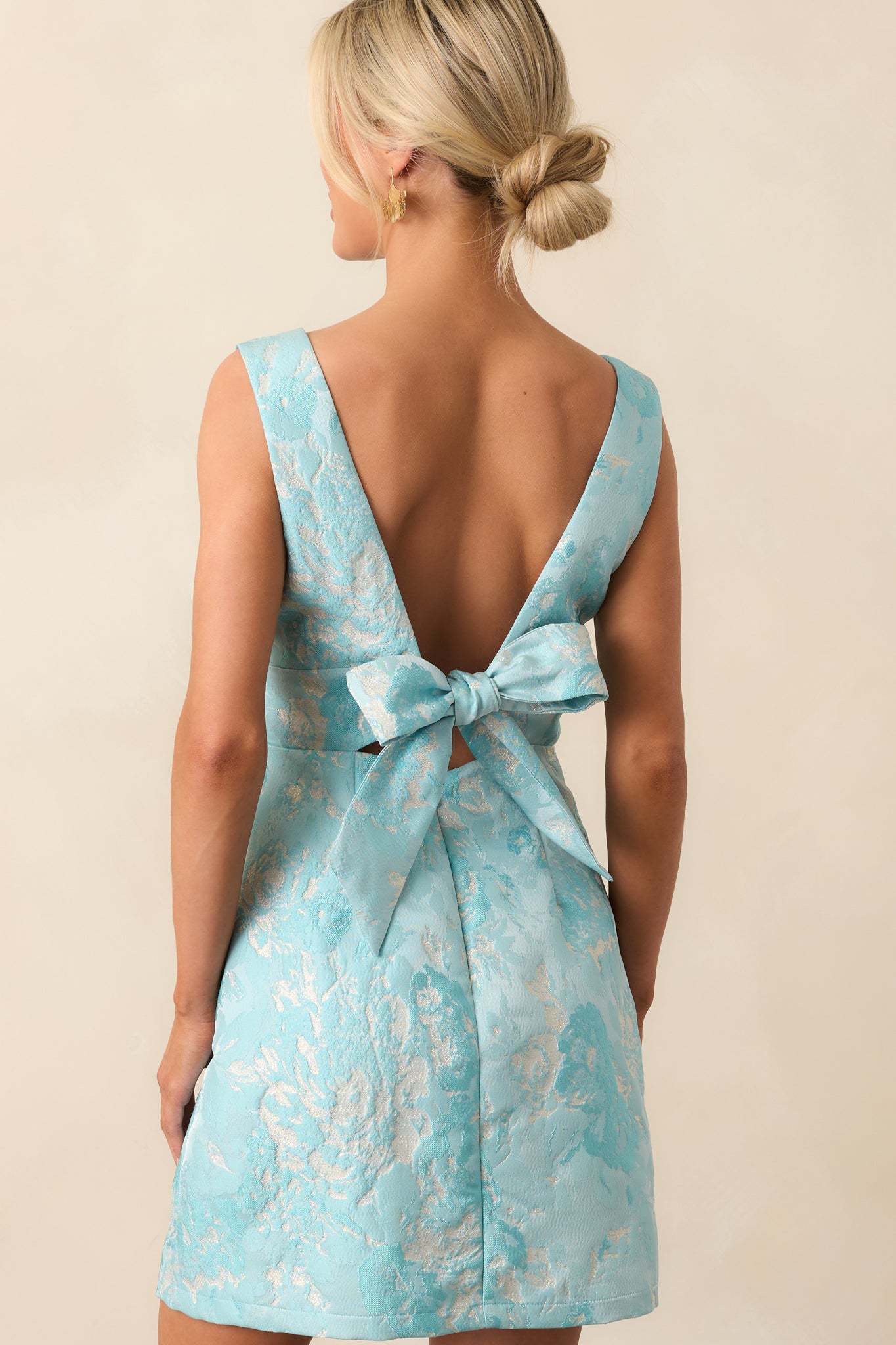 A view from behind of the light blue mini dress showing the discreet back zipper and self-tie bow.