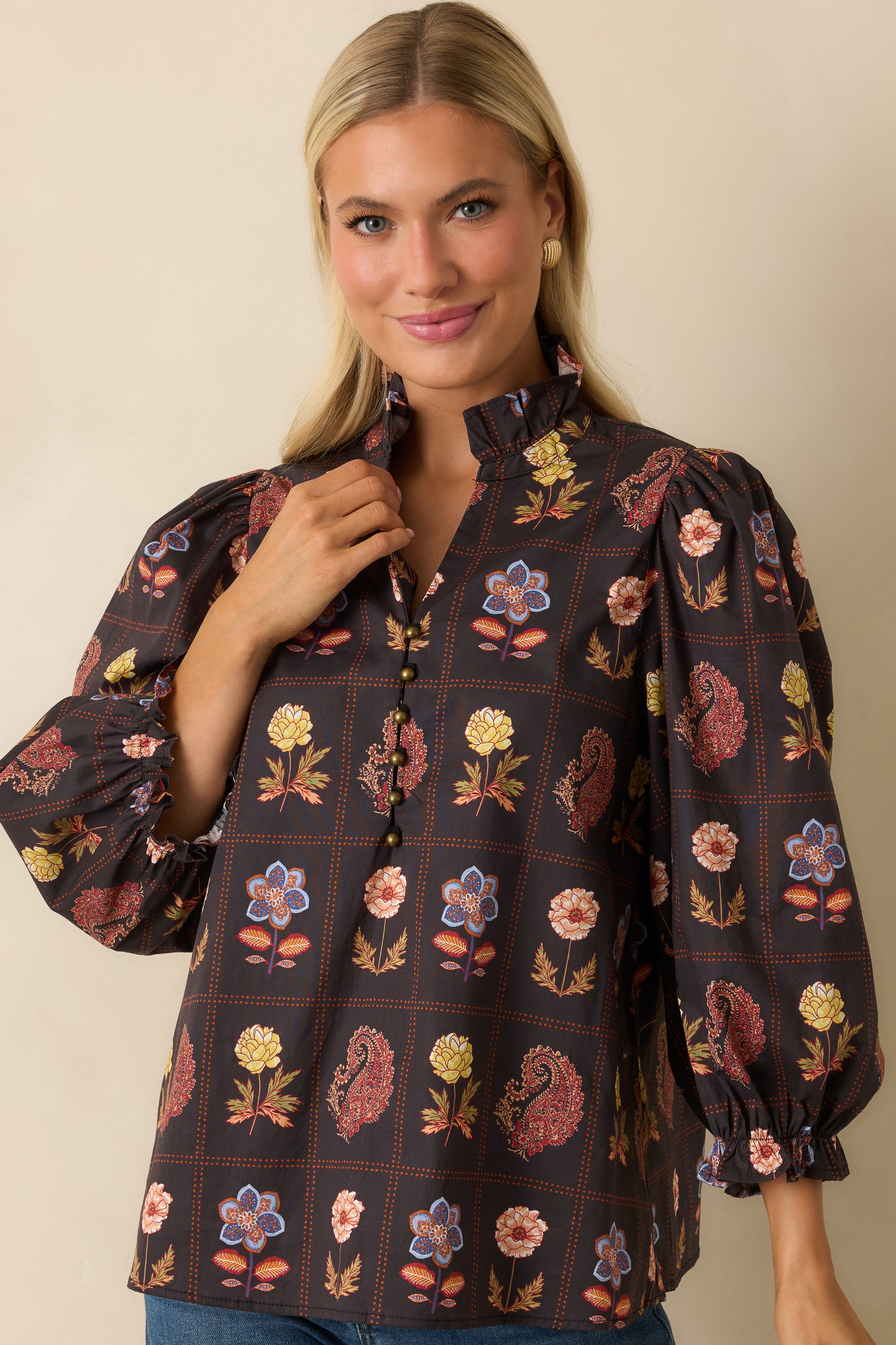 Detailed view of the puff sleeve and elastic ruffle cuff with multicolor floral embroidery.