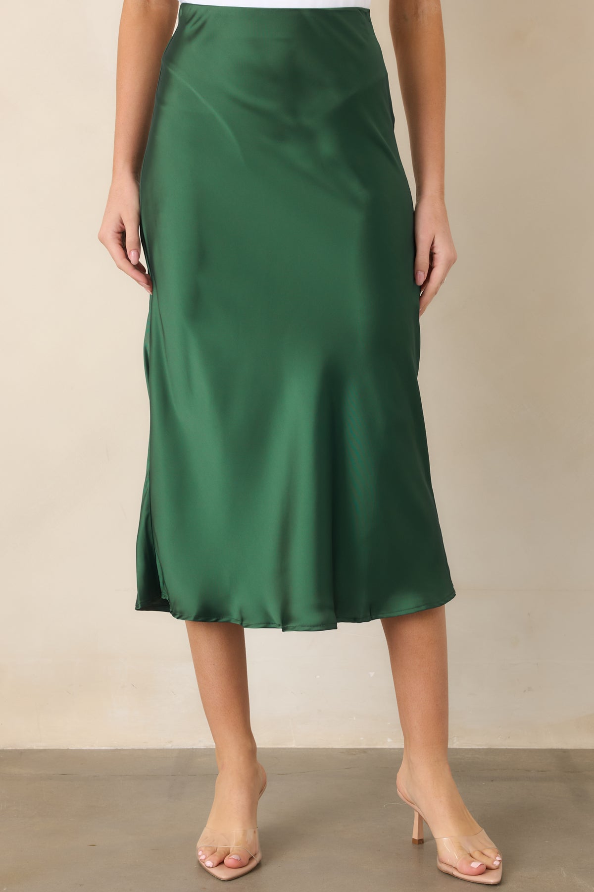 Pull-on satin skirt showcasing the polished sheen, flexible waistband, softly contoured hips, and flowing midi-length silhouette.