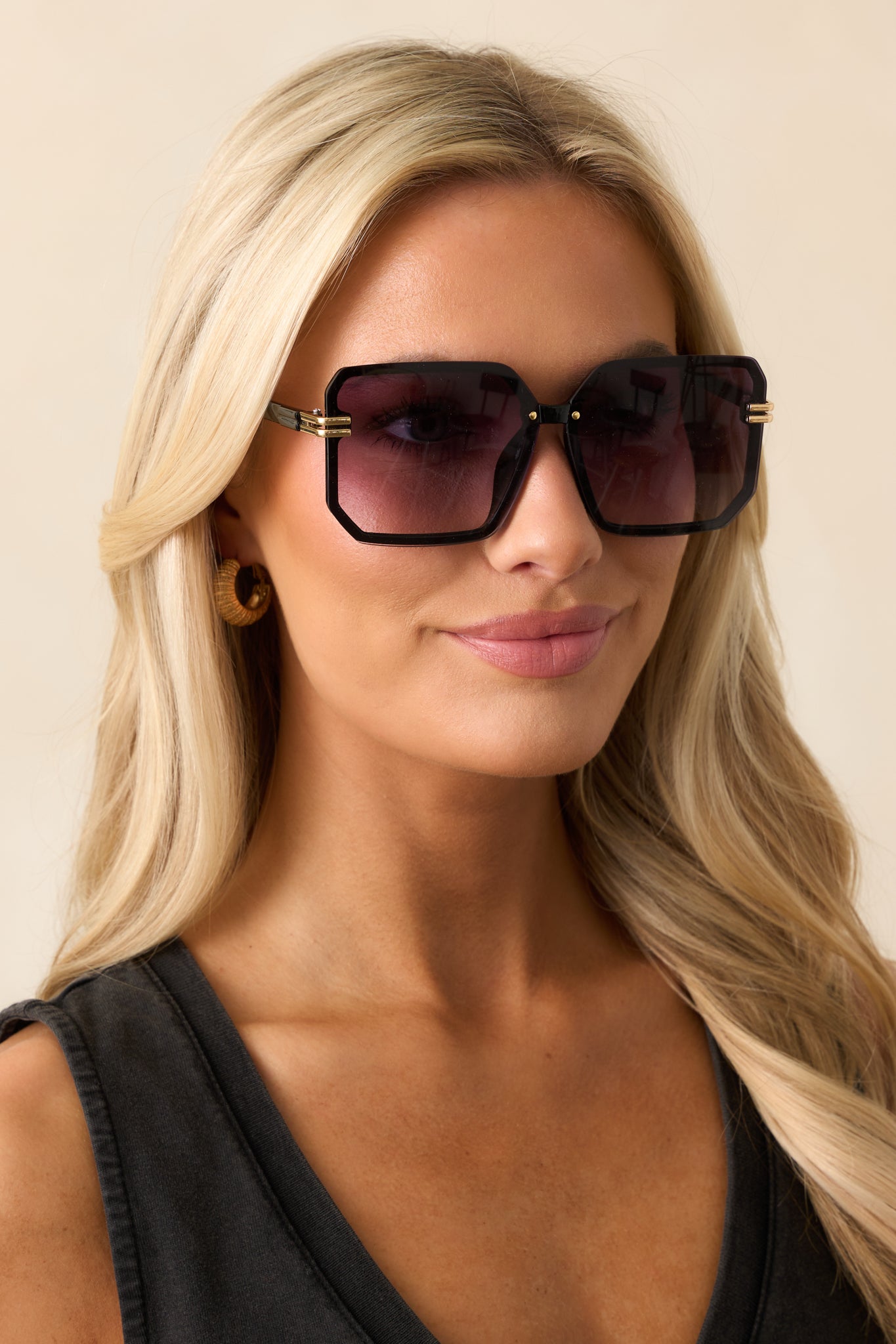 Purple sunglasses with square frames, featuring a slim nose piece and gold accents on the sides of the frames for a sleek and modern look.