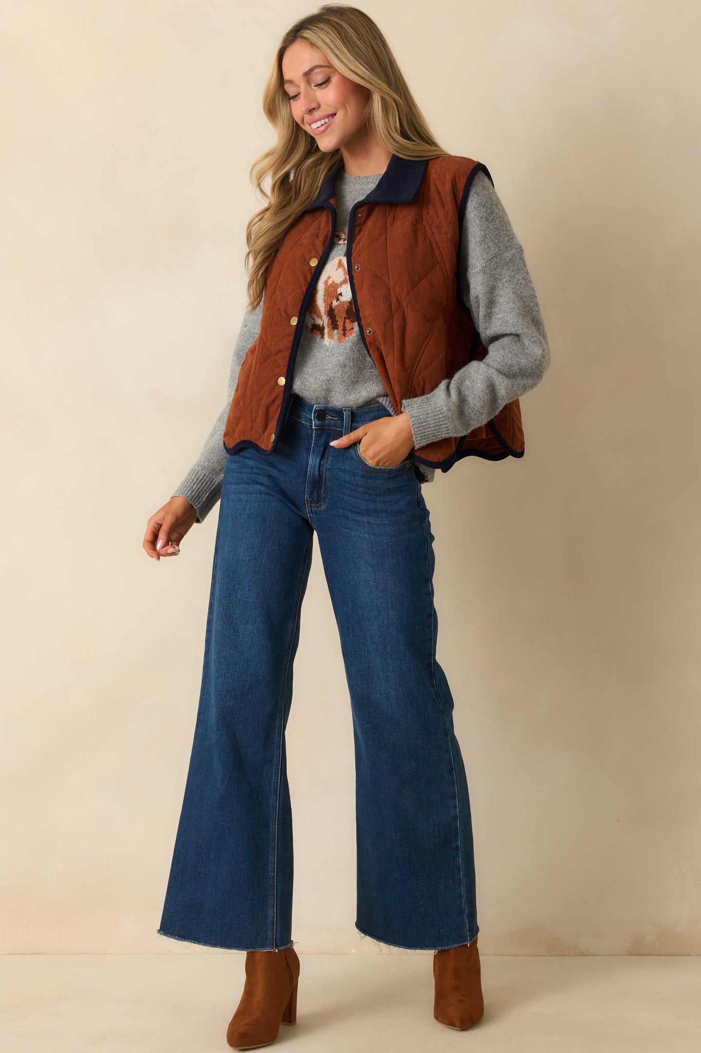 Front view of quilted corduroy vest highlighting functional pockets and navy trim.