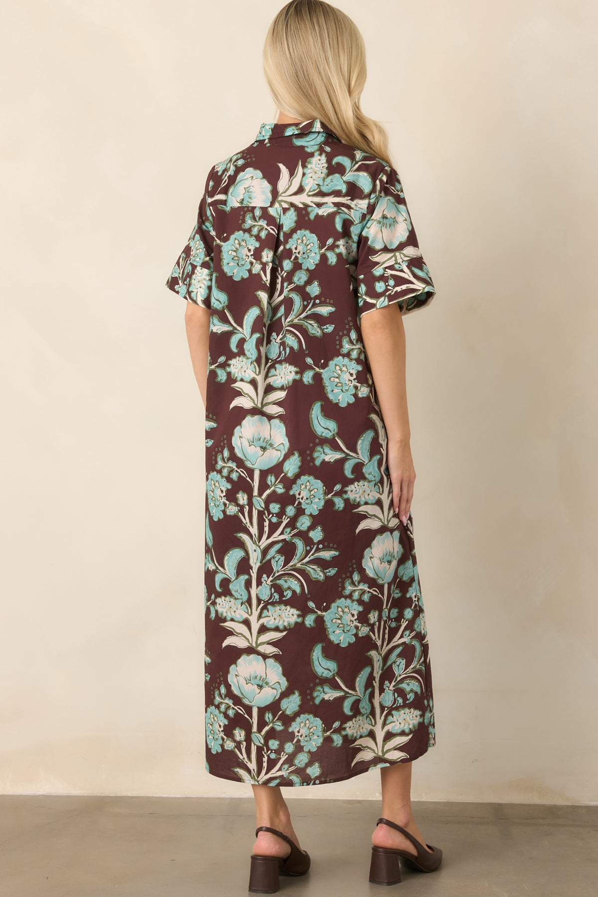 Rear view shows the rich brown botanical print, short sleeves, relaxed shape, and back pleat for added ease.