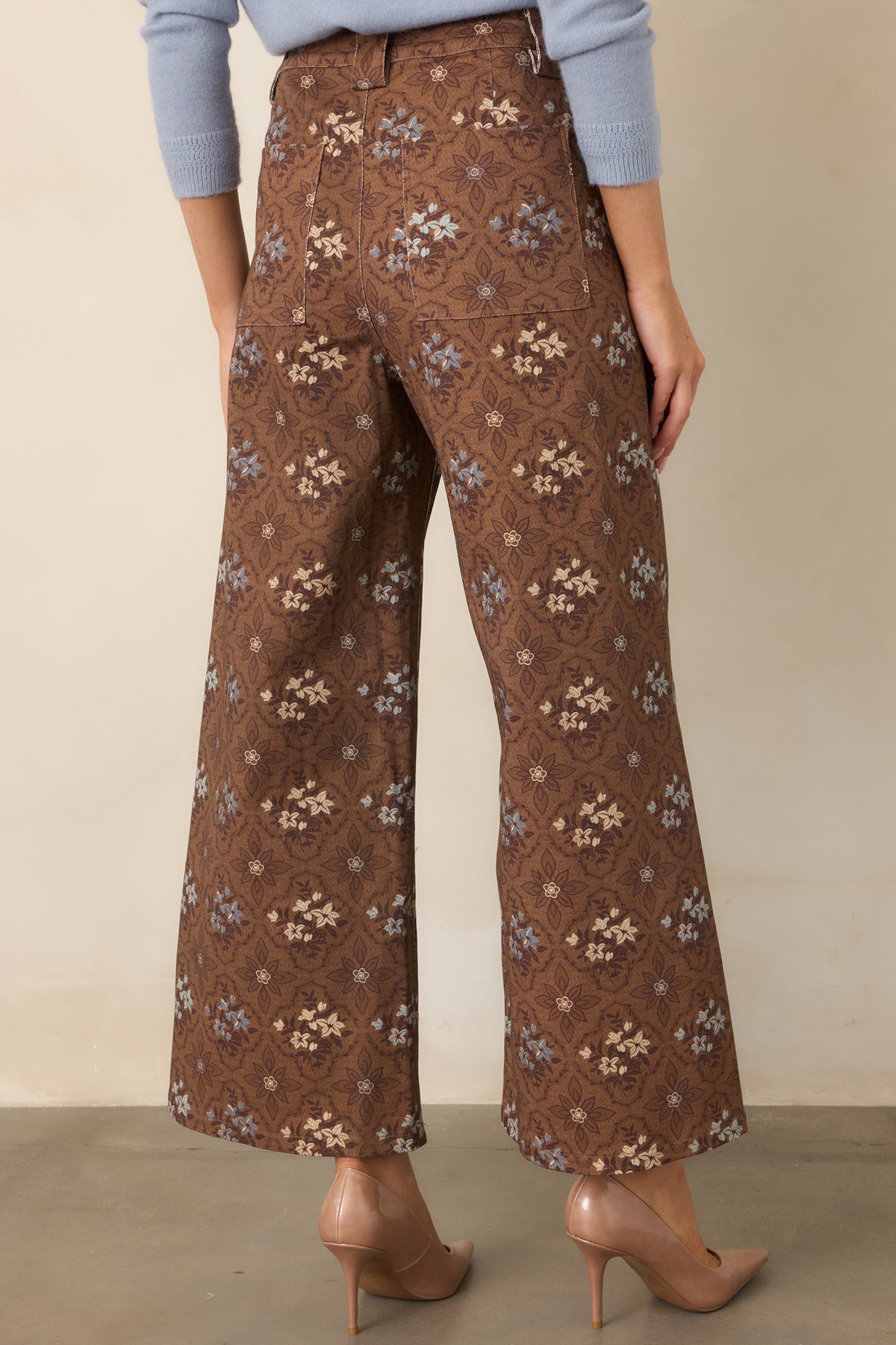 Rear of the brown floral cropped pants featuring back patch pockets and an allover medallion pattern.