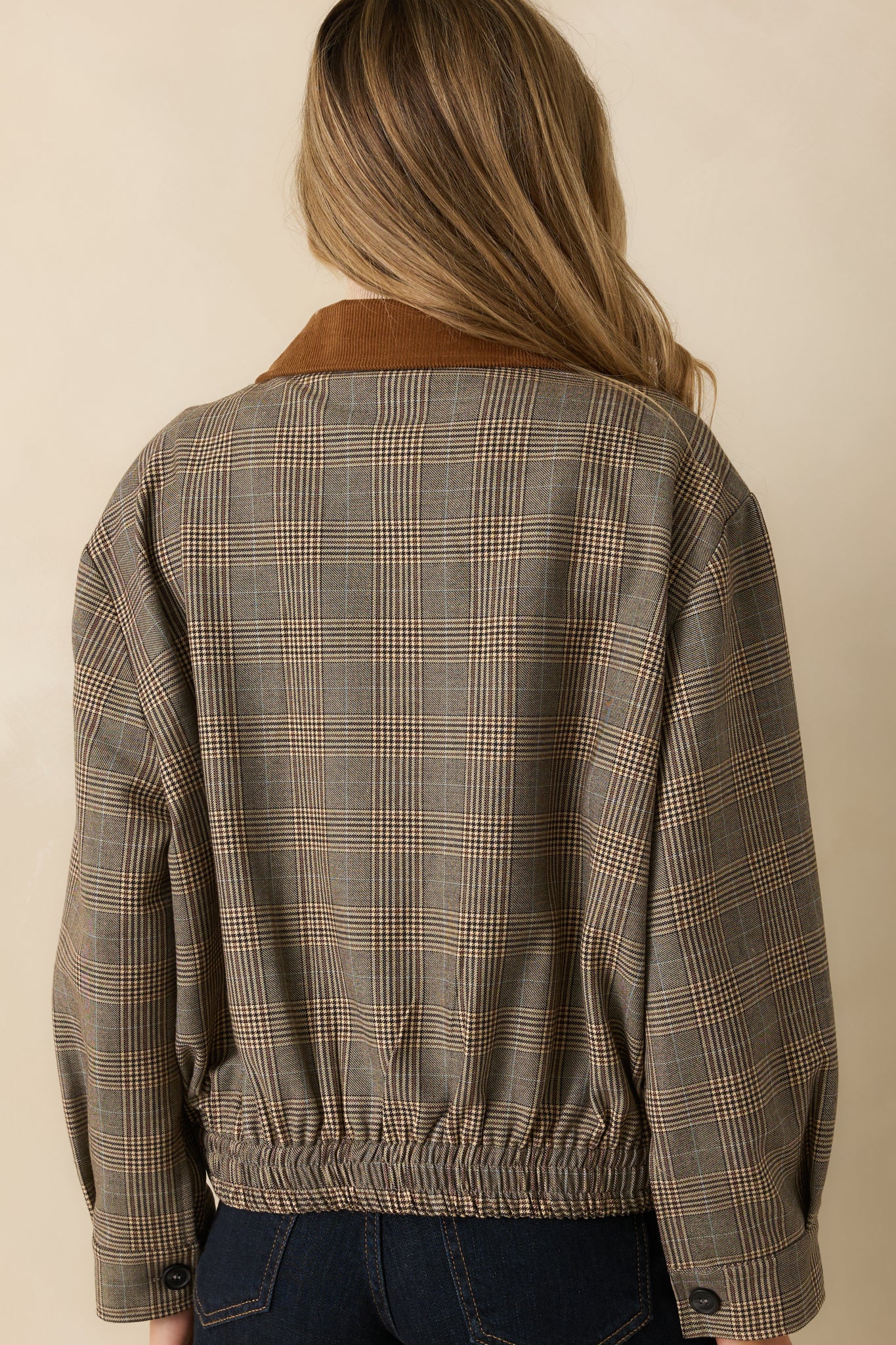 Rear view of the brown multi plaid woven bomber jacket showing the relaxed fit and elastic hem.