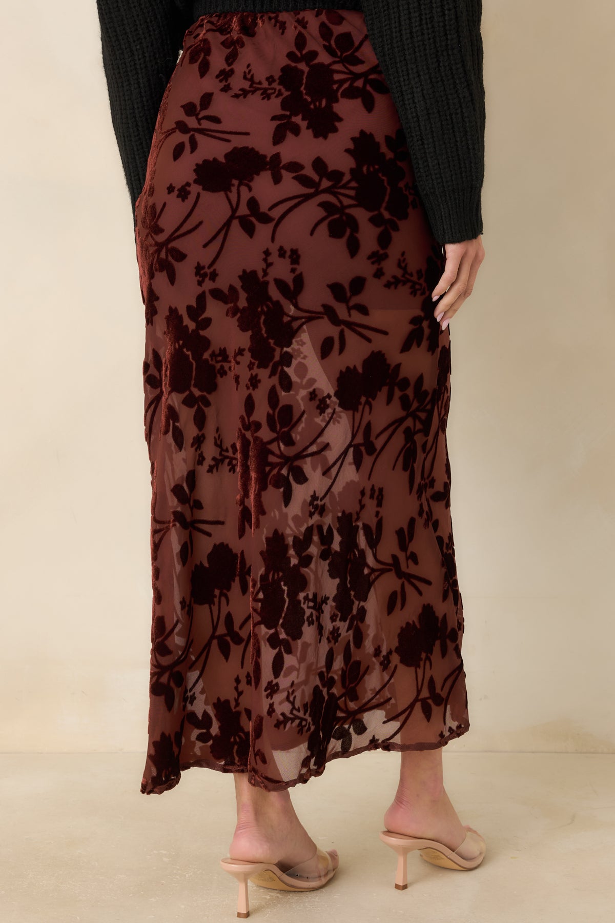 Rear of the burgundy floral velvet burnout midi skirt showing its slim shape, sheer mesh base, and fluid hem.