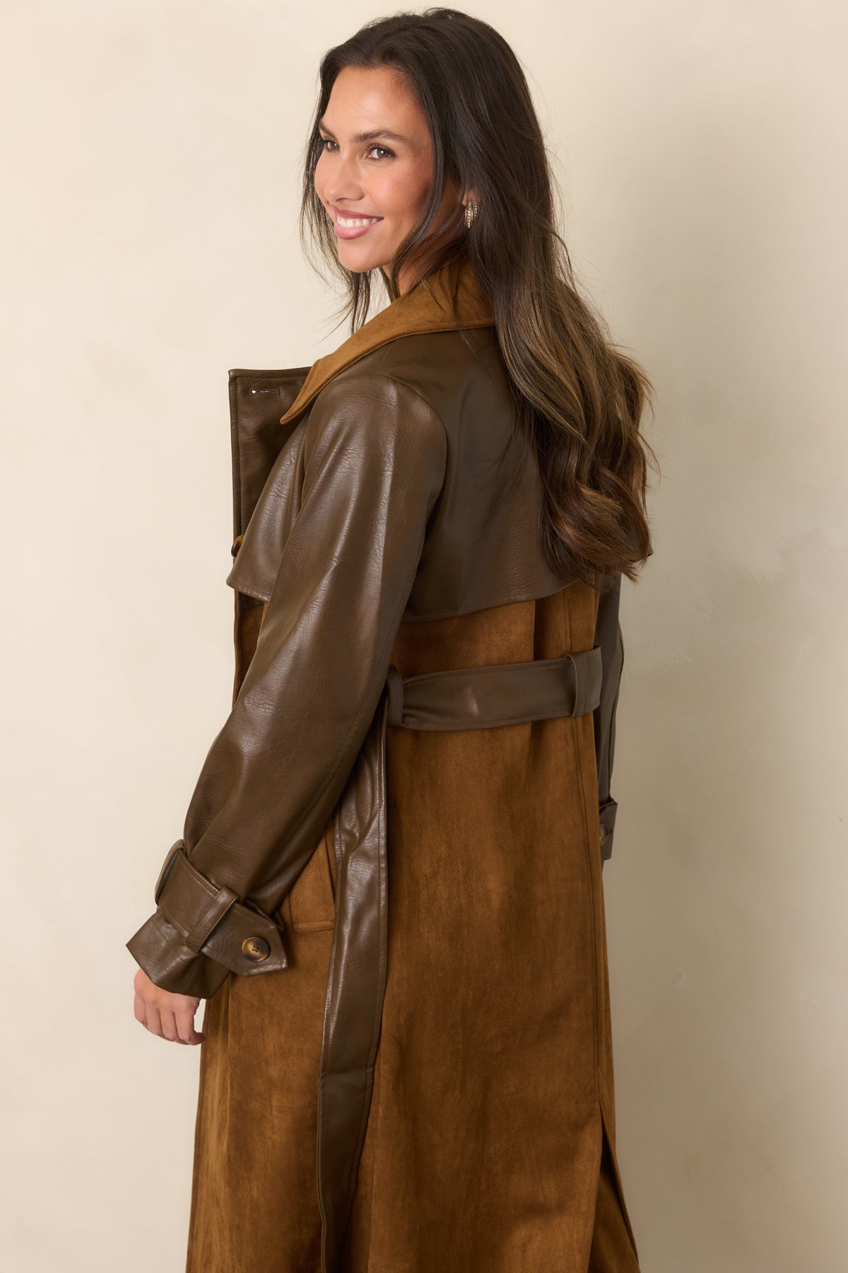 Rear of the long caramel coat showing the suede-look body, brown faux leather sleeves, and coordinating tie belt.
