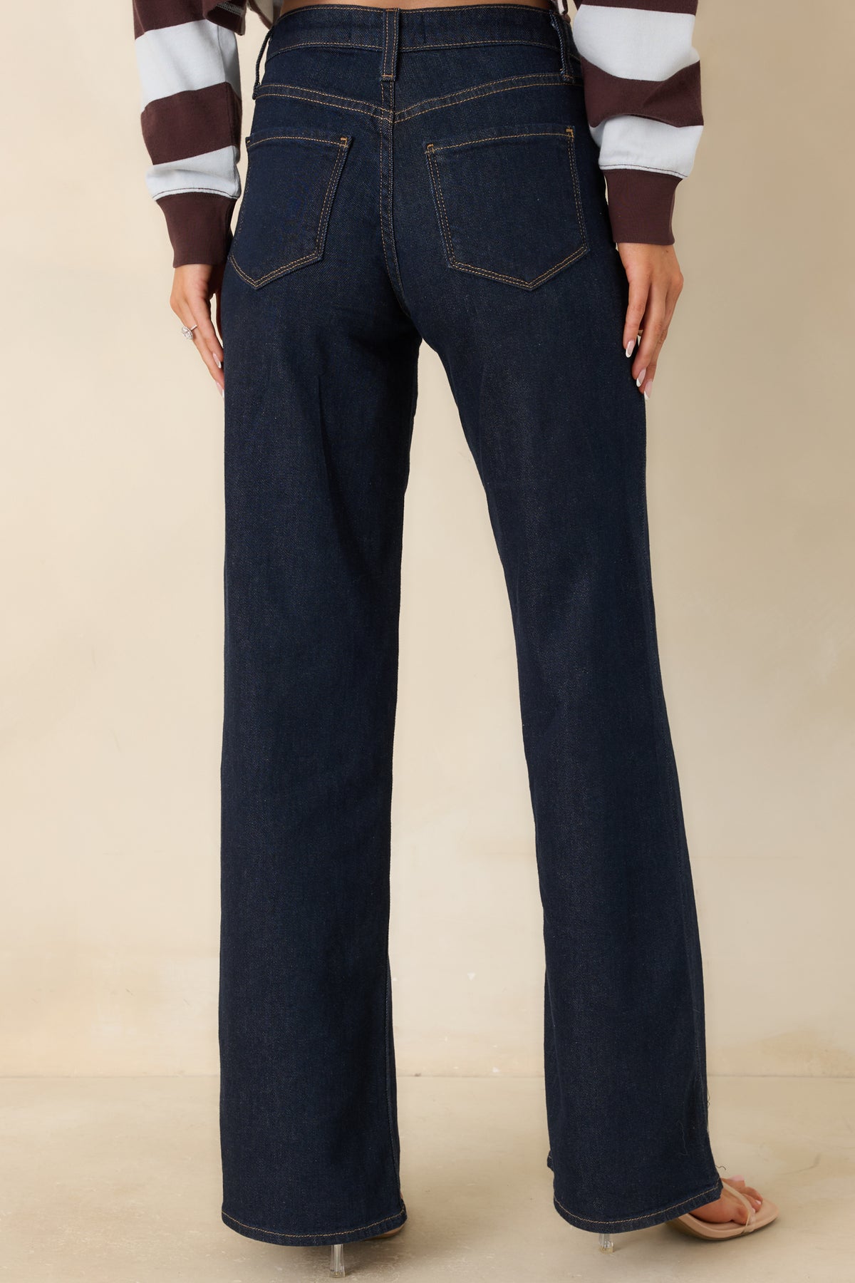 Rear of the dark wash jeans featuring a high-rise waist and wide-leg cut.
