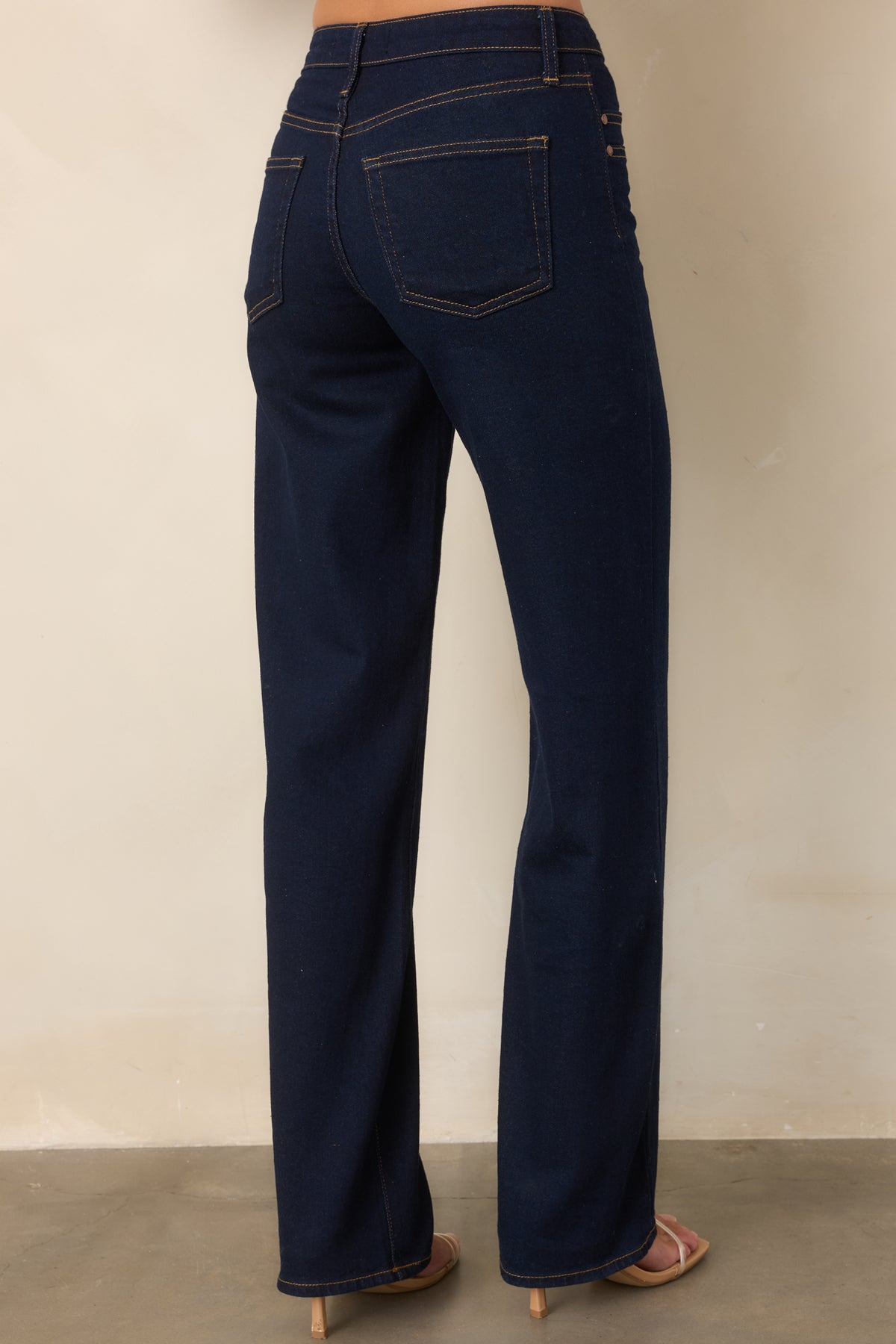 Rear of the deep indigo jeans featuring the high-rise waist and classic back pockets.