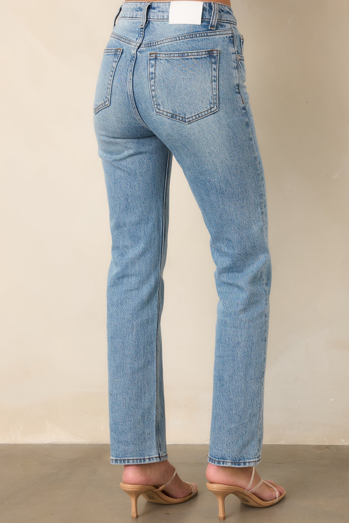 Rear view of the high-rise denim jeans showcasing the back pockets and straight-leg silhouette.