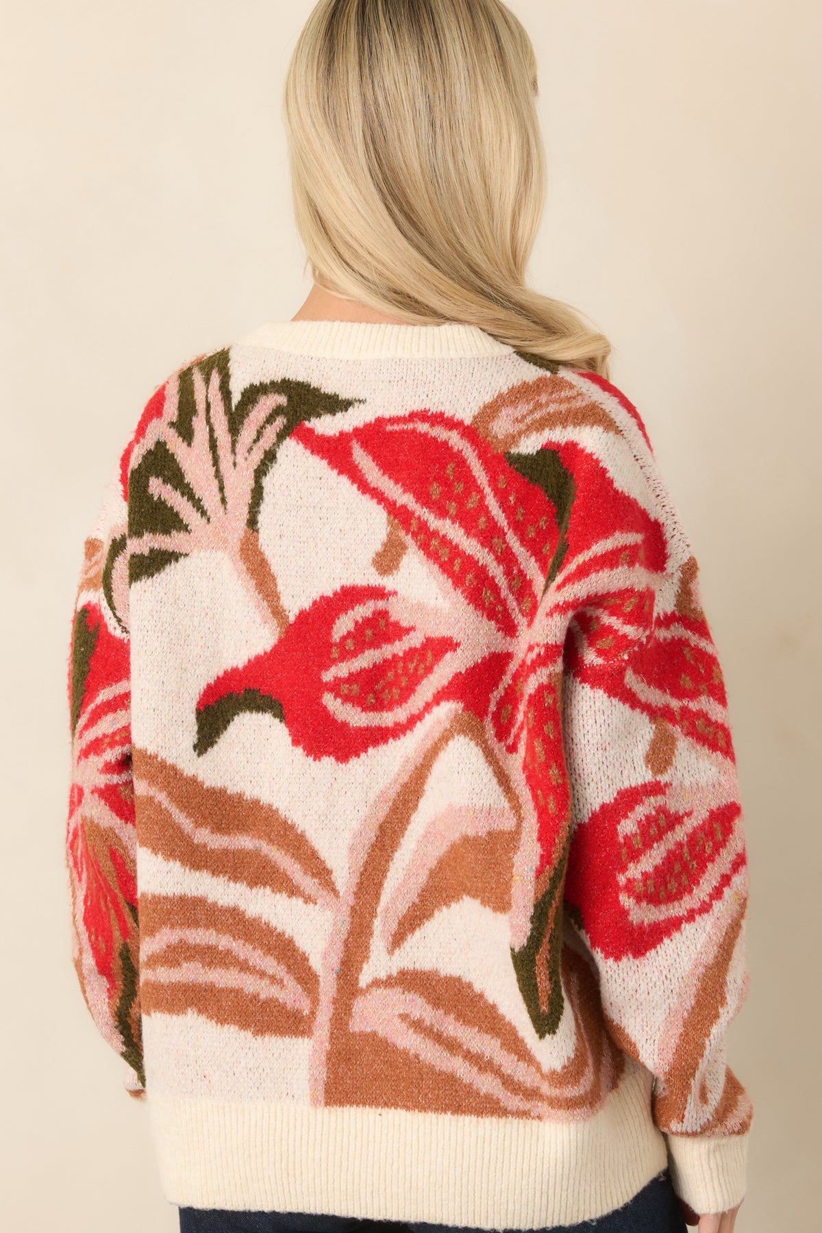 Rear of the ivory floral knit top showcasing its relaxed silhouette, dropped shoulders, long sleeves, and ribbed hem.