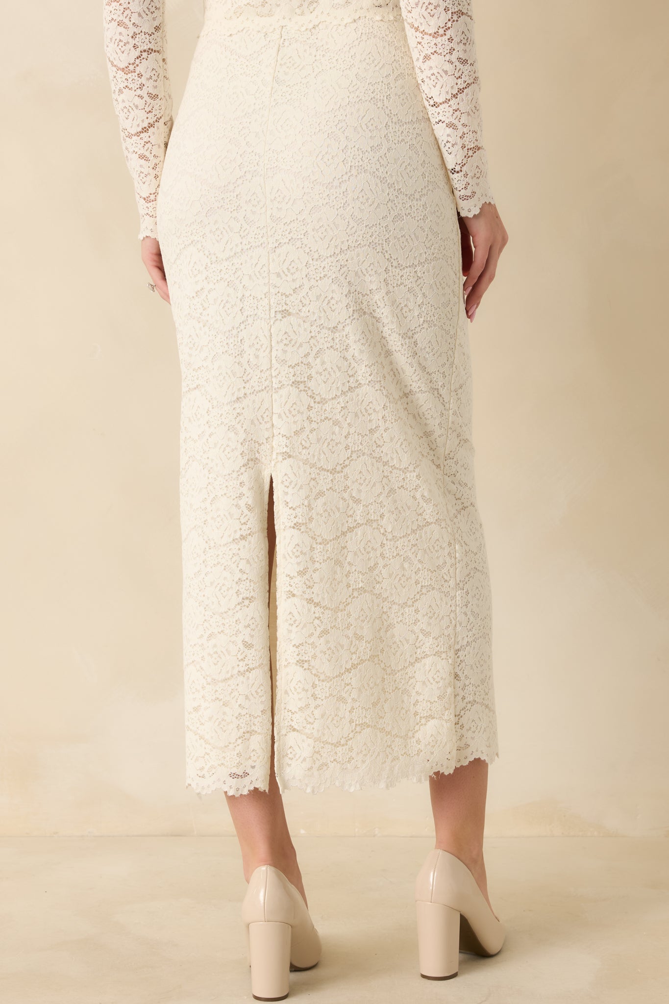 Back view of ivory lace midi skirt showing back hem slit and fitted waistband.