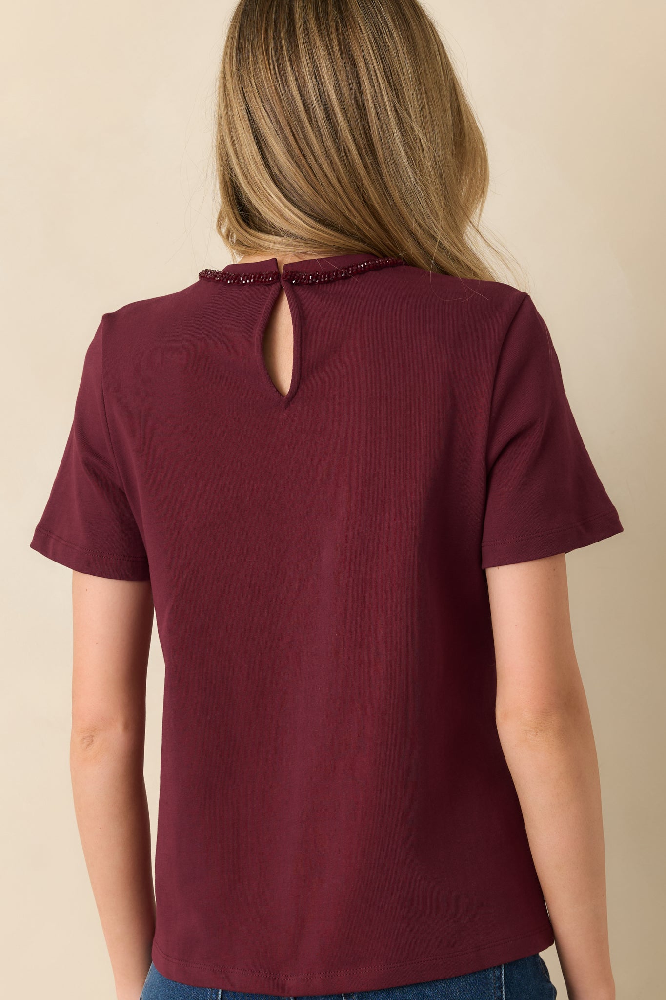 Back view highlighting the key-hole back closure, short sleeves, and straight hemline.
