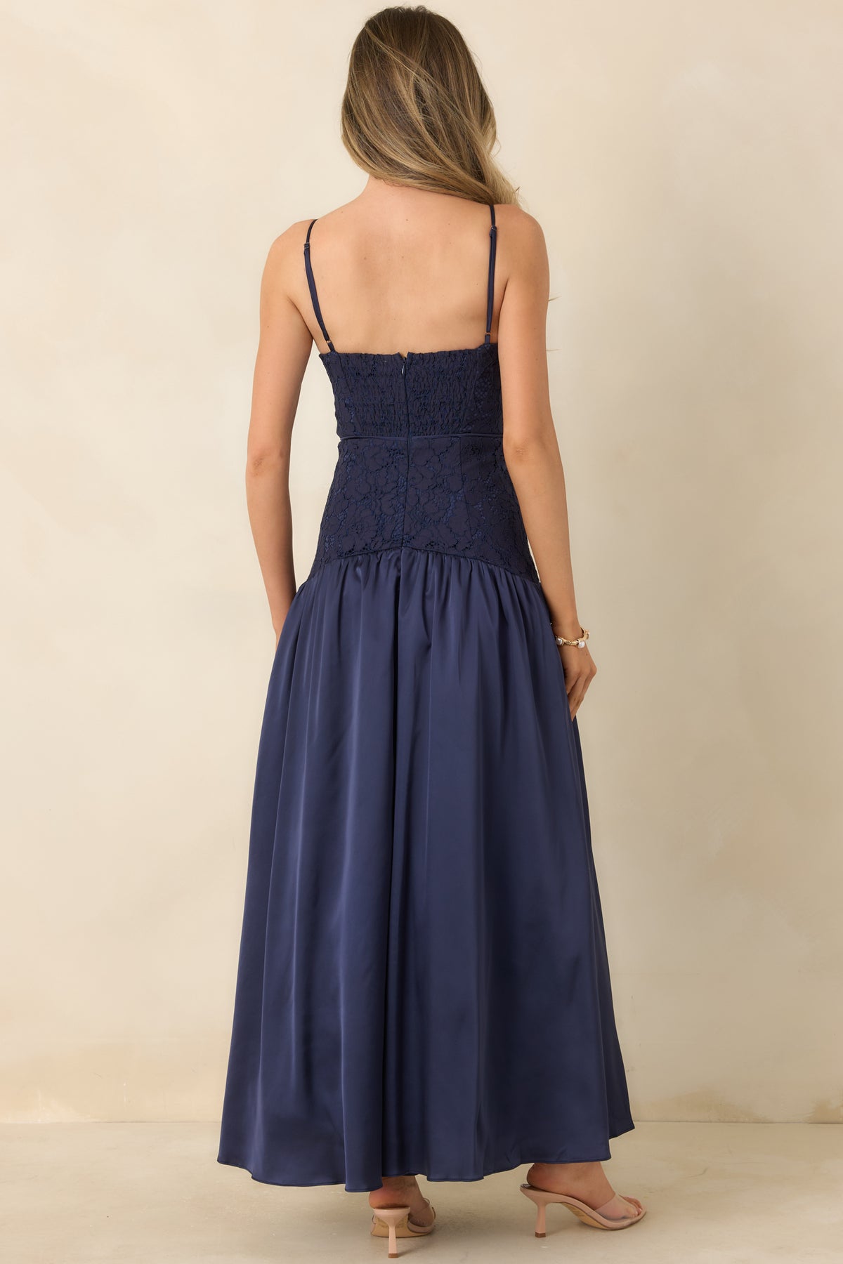 Rear view of the lace bustier maxi dress featuring a partially smocked back, center zipper, and adjustable straps.