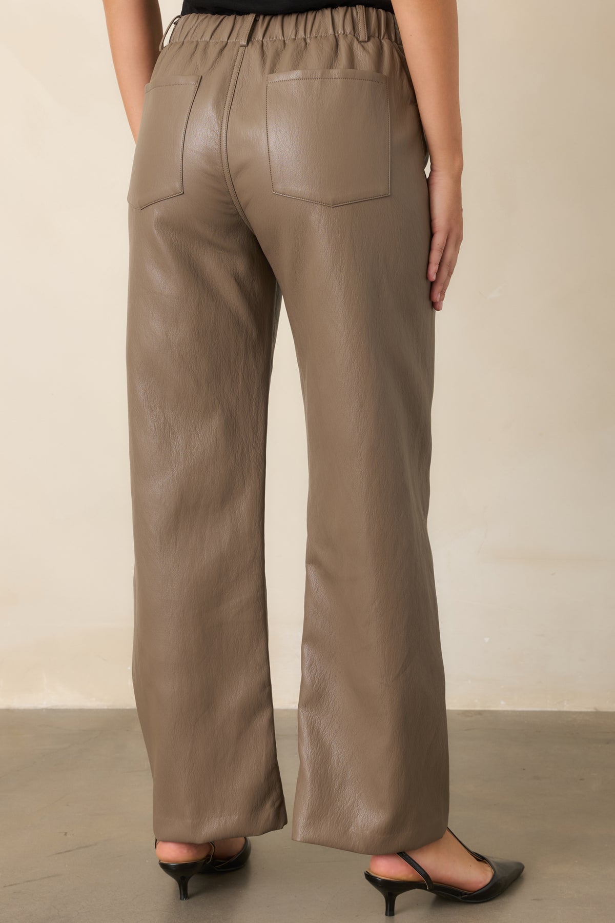 Rear of the light brown faux leather pants with functional back patch pockets and wide legs.