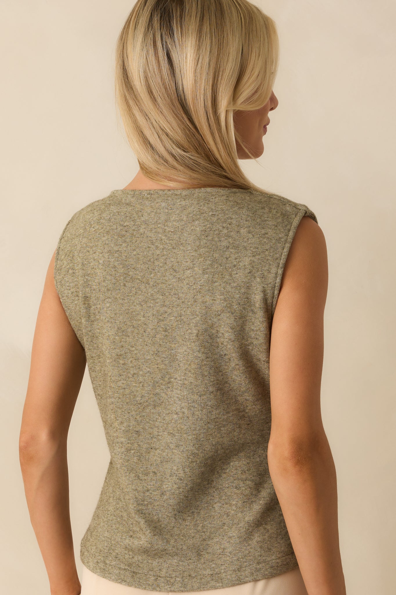 Rear view of the light olive green sweater vest, showing the knit fabric and straight hemline without any embellishments.