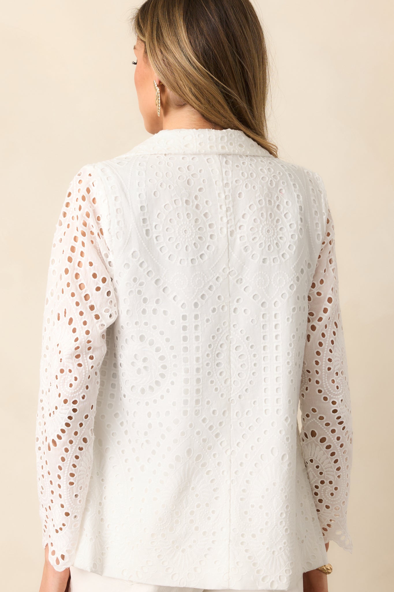 The rear of this white blazer features an all-over eyelet embroidered overlay, creating a soft yet structured finish.