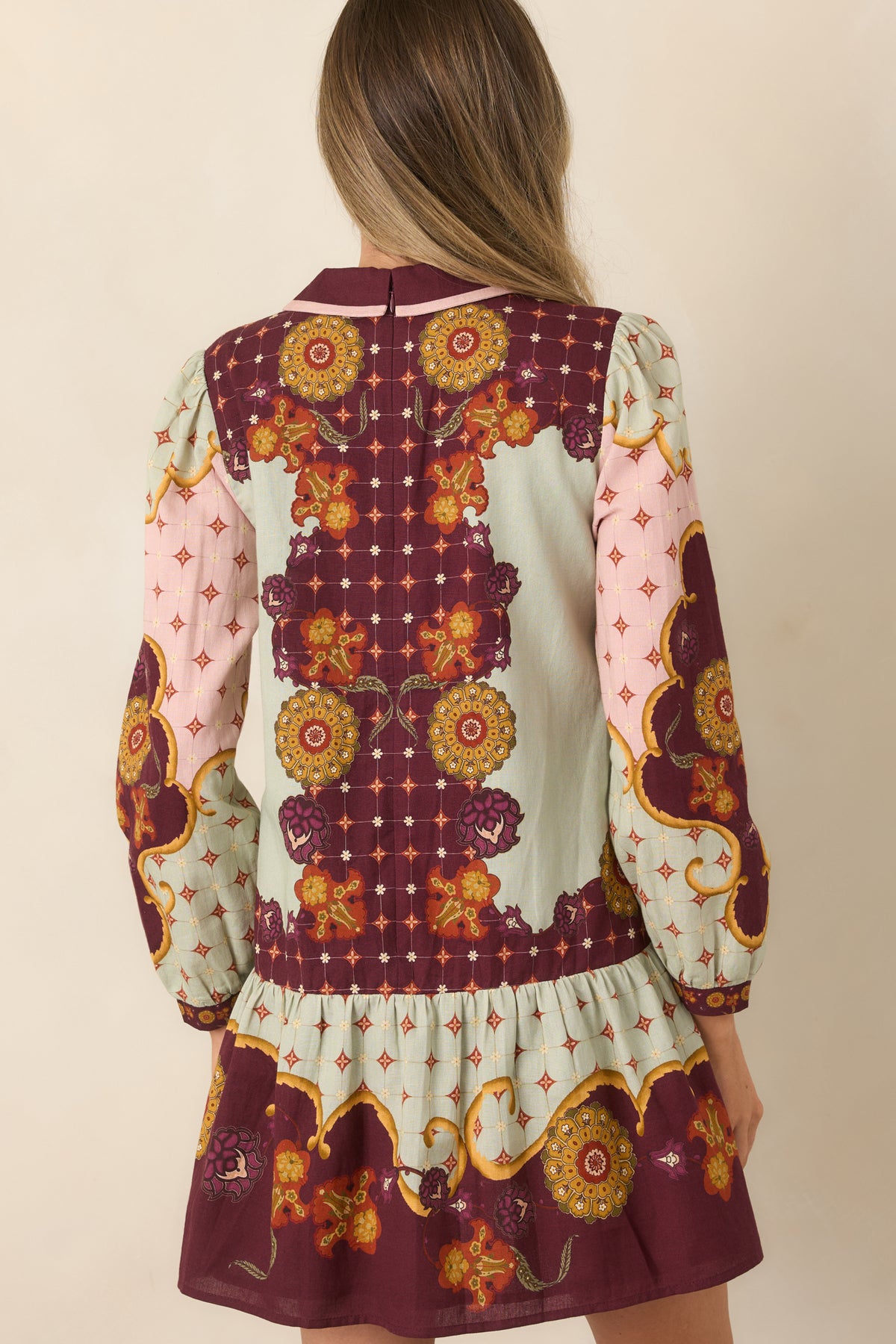 Rear of the printed mini dress showing the concealed zipper and softly flounced hem.