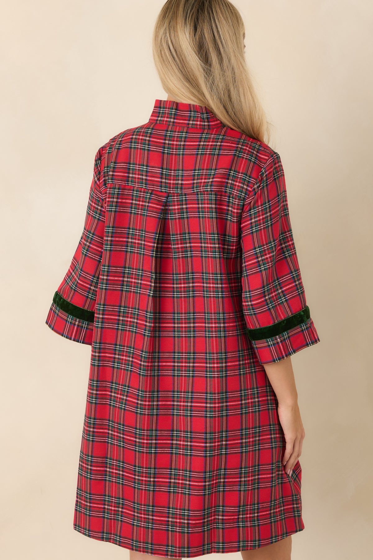 Rear view of the red and green plaid mini dress featuring a back pleat and a relaxed A-line silhouette.