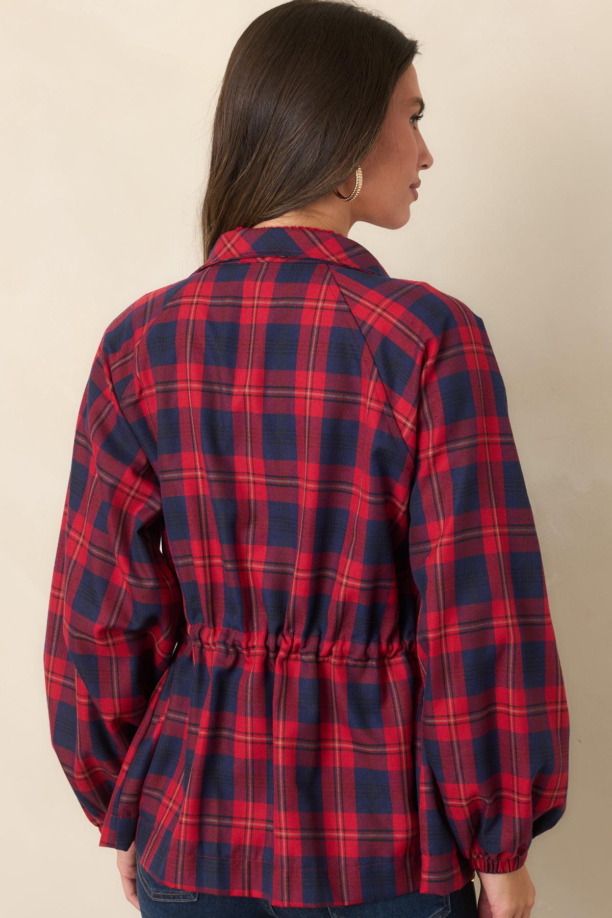 Rear view of the red and navy plaid jacket showing its adjustable drawstring waist and long sleeves.
