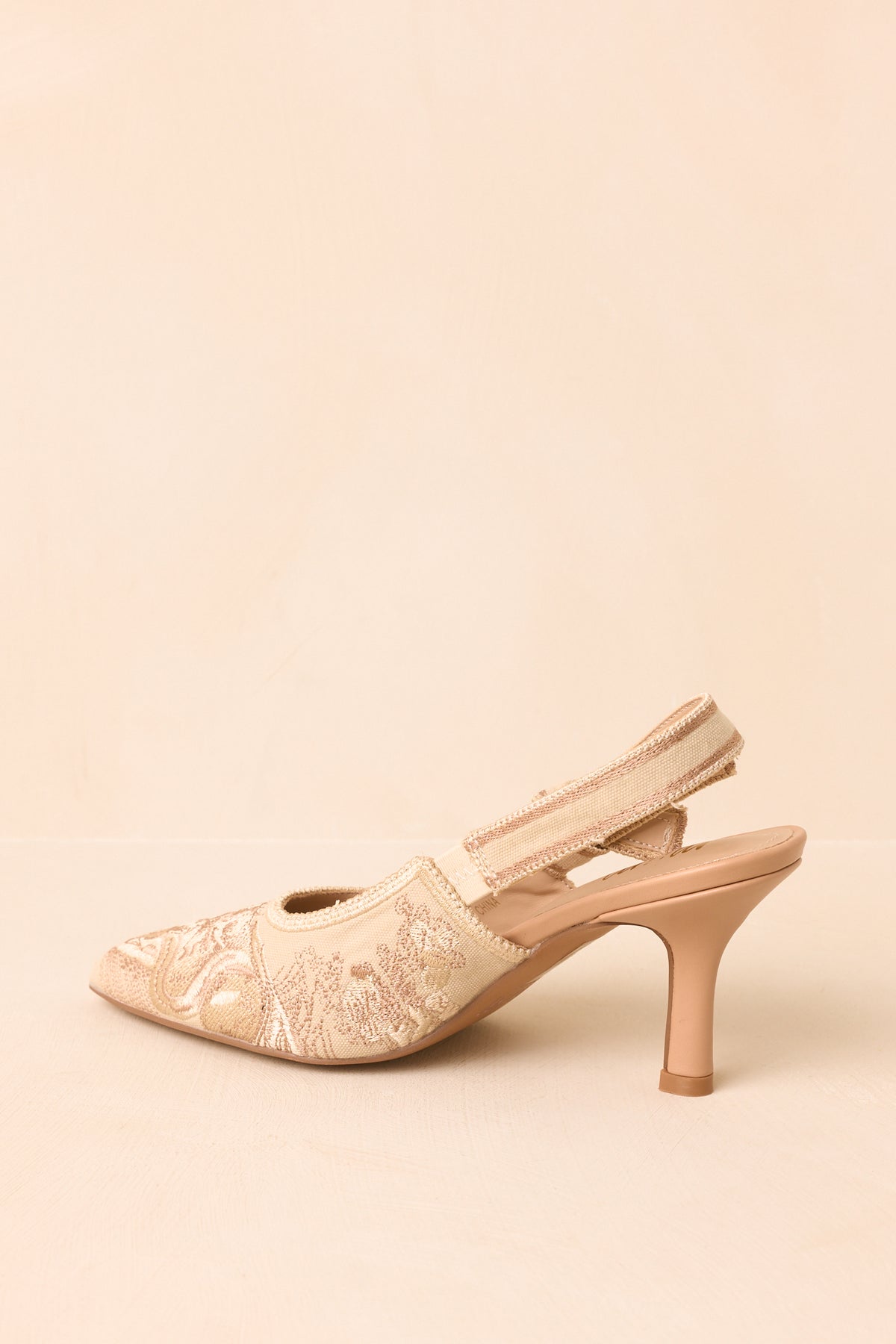 Rear view of the soft gold slingback heels showing the elastic straps, embroidered fabric, and mid-height heels.