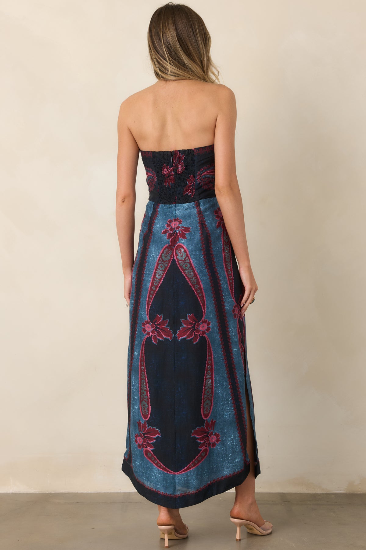 Rear of the strapless dress showing the smocked back, concealed zipper, fitted bodice, and flowing flared skirt.