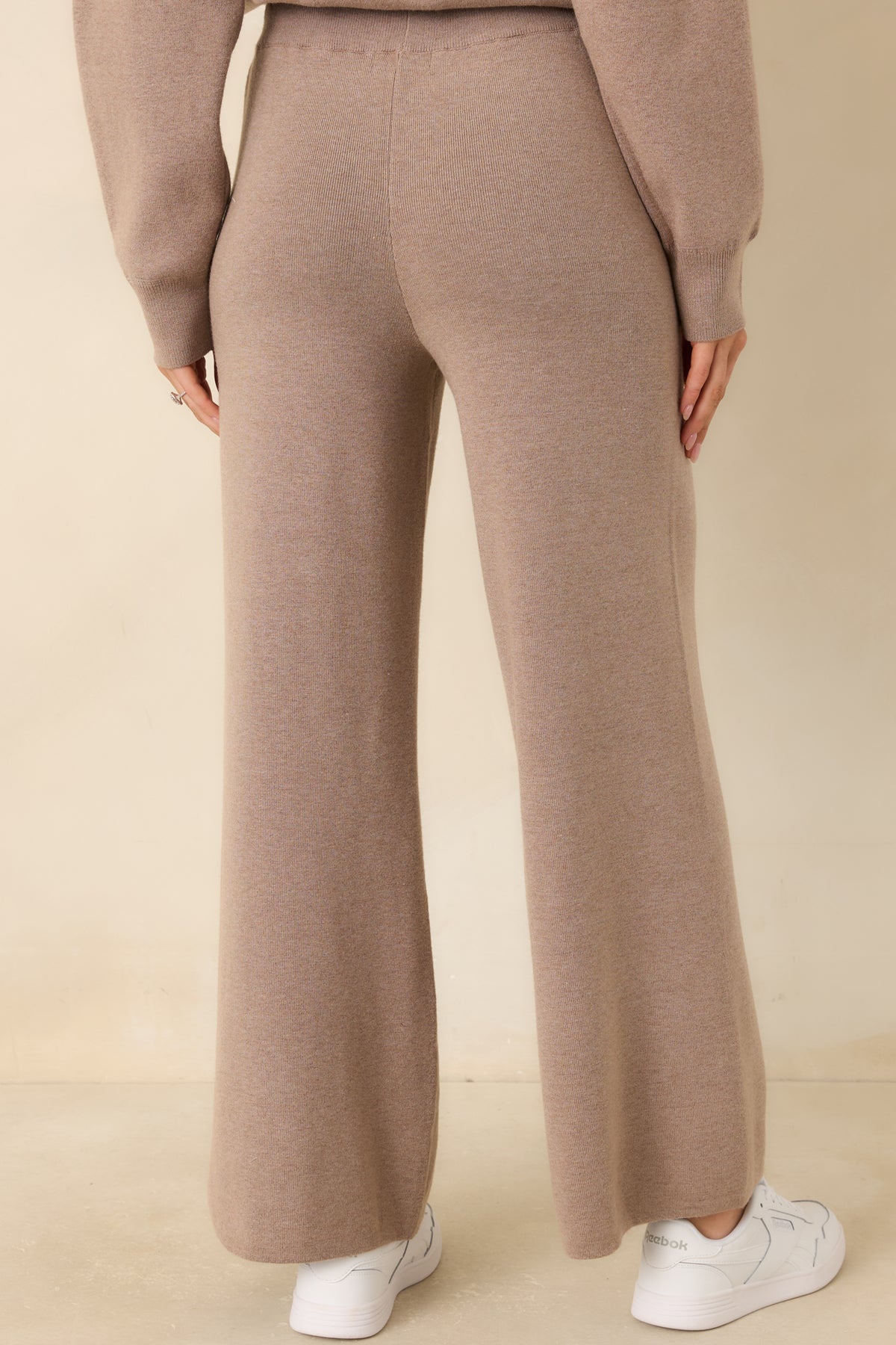 Rear of the sweater-knit pants featuring a high-rise waistband and relaxed, straight wide legs.